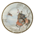 A late Meiji period Japanese porcelain plate in the Yokohama-e export tradition, painted with two mounted samurai crossing water in a winter landscape, signed by the artist Ikkei and made by Nakamura of Yokohama.
