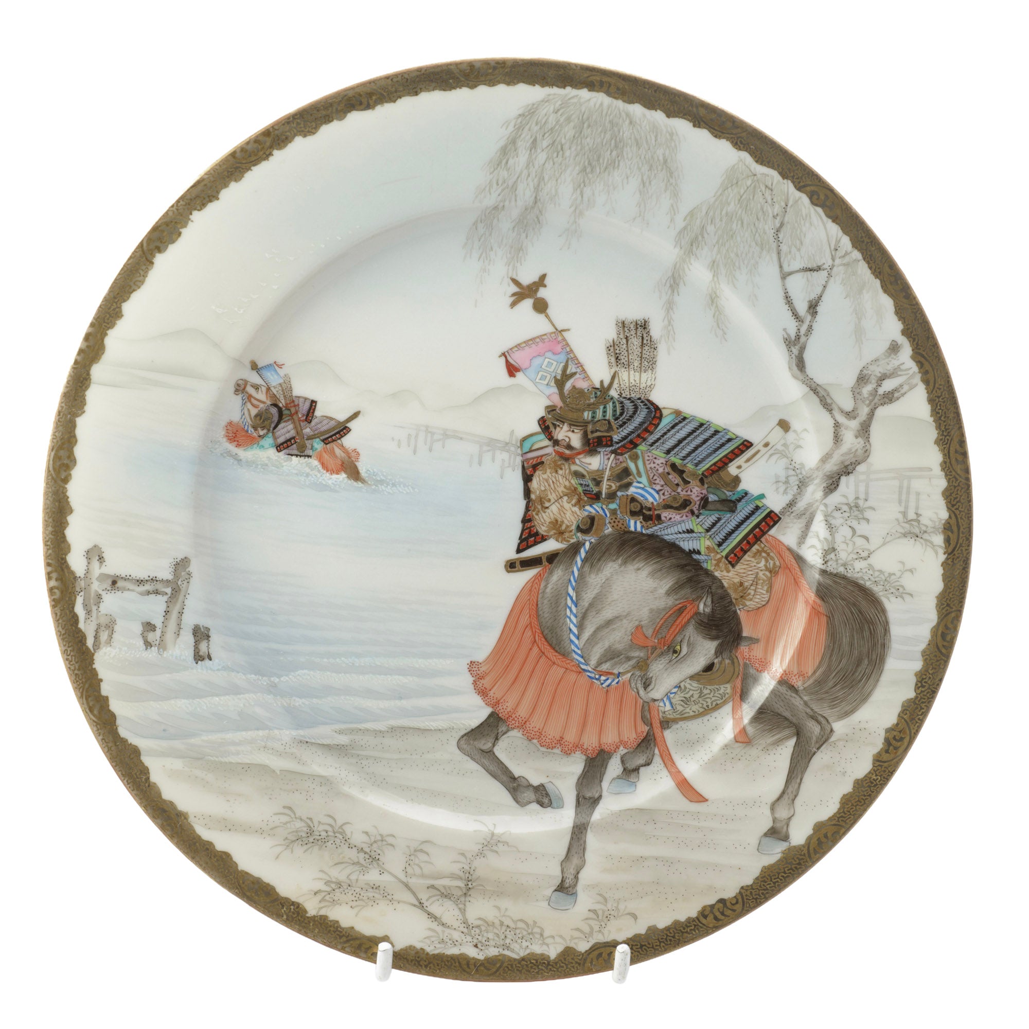 A late Meiji period Japanese porcelain plate in the Yokohama-e export tradition, painted with two mounted samurai crossing water in a winter landscape, signed by the artist Ikkei and made by Nakamura of Yokohama.