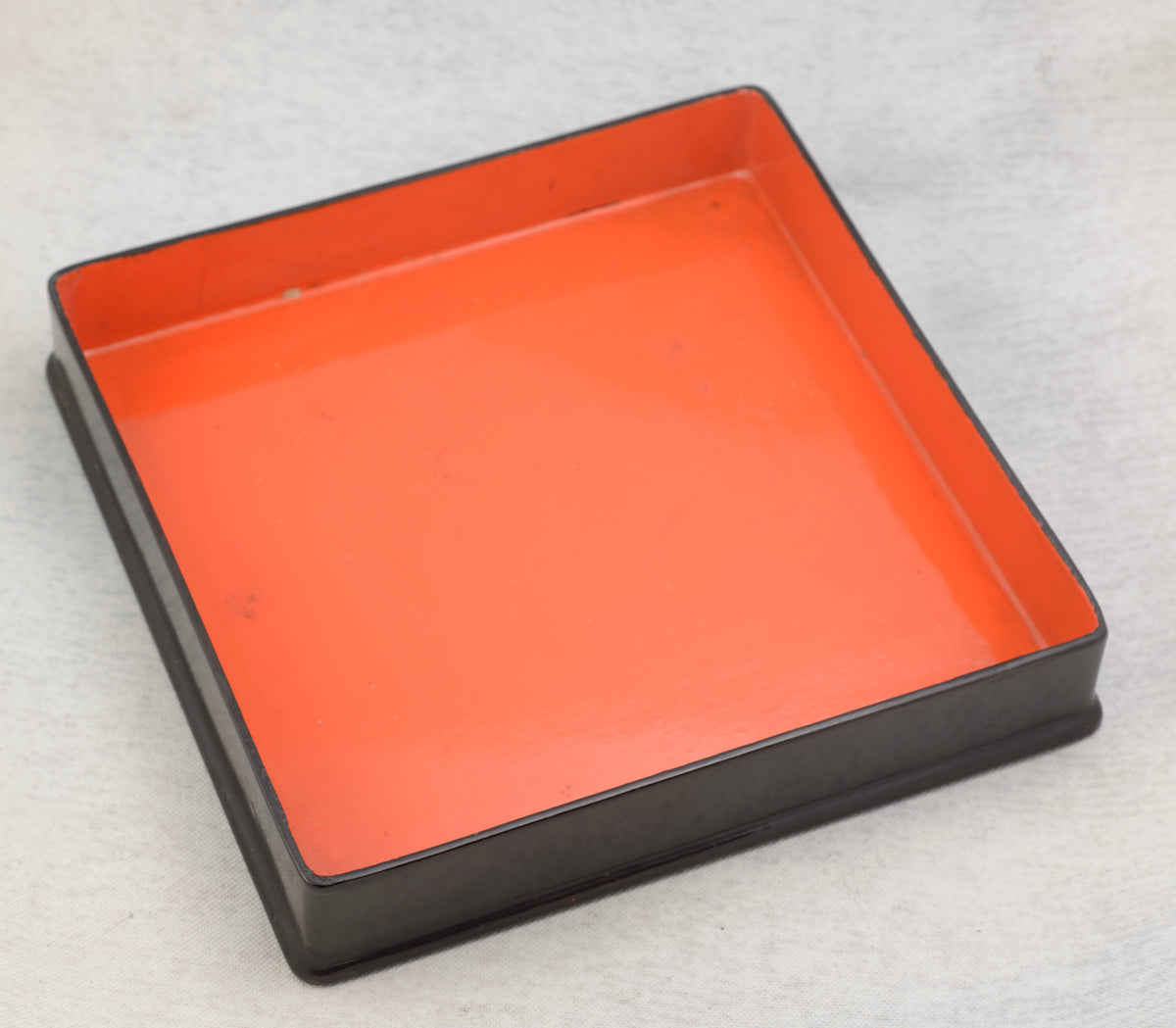 Open late Victorian English black lacquer box showing its vivid red interior