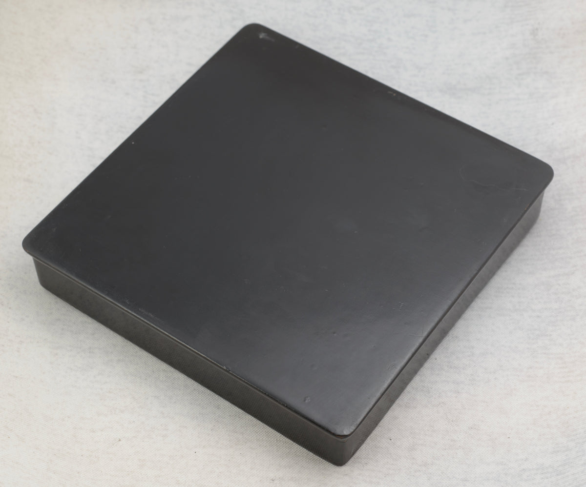Detailed view of the painted white daisies, foliage and smaller flowers on the glossy black lacquer box