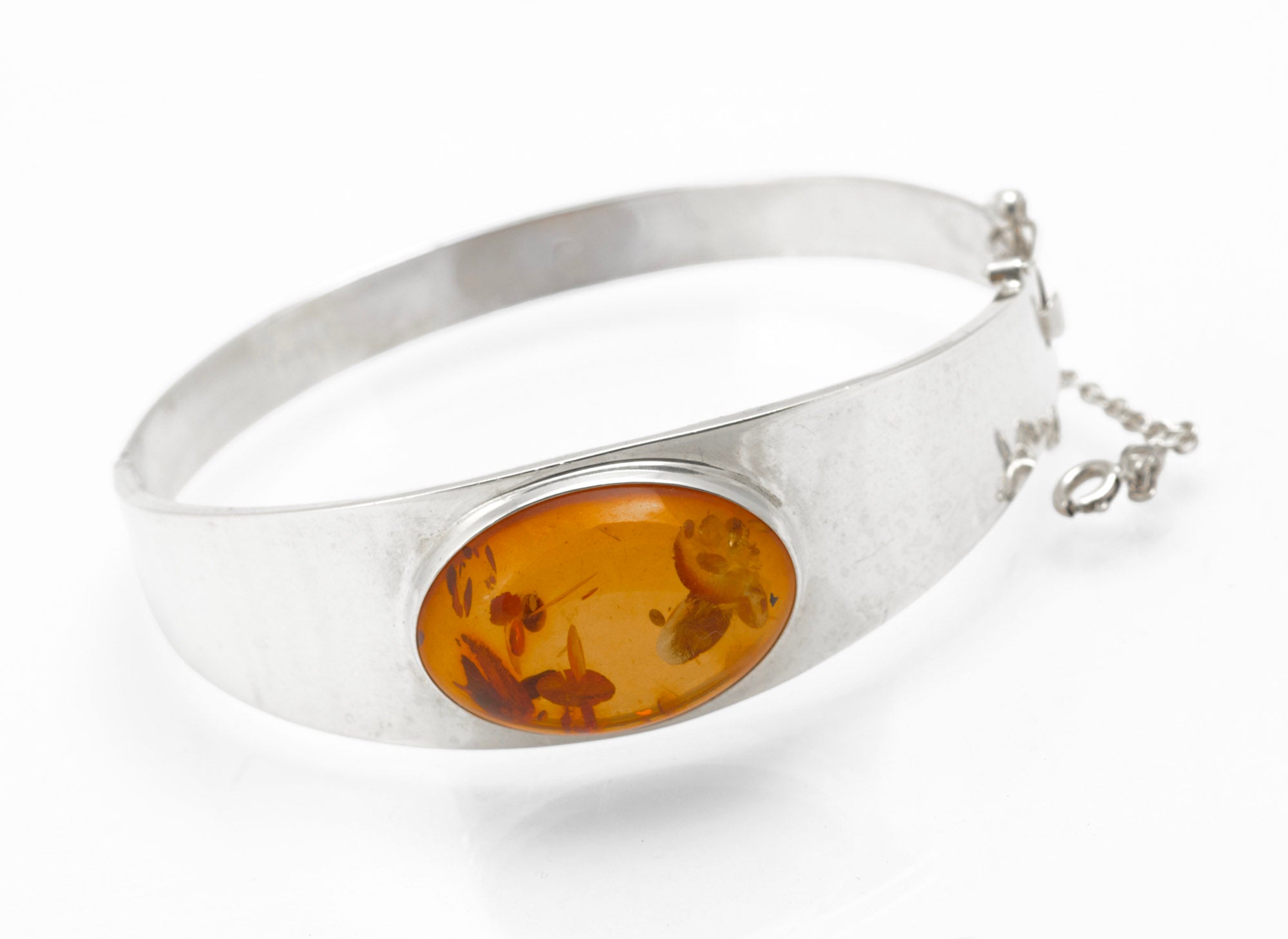 Vintage Sterling Silver and Amber Bangle - front view showing oval amber cabochon on grey background