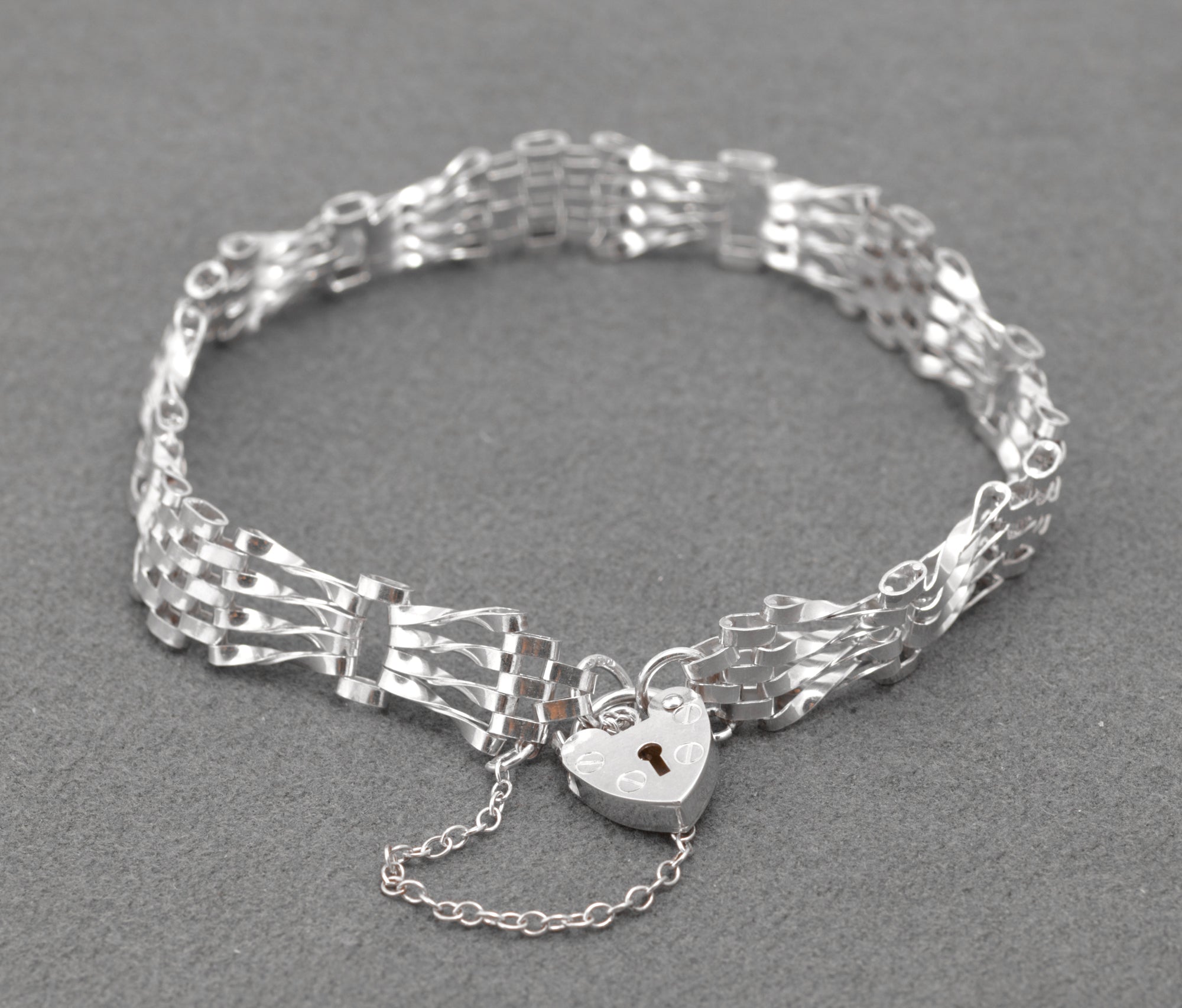 Vintage Sterling Silver Gate Bracelet - full view with heart padlock clasp and safety chain on grey background