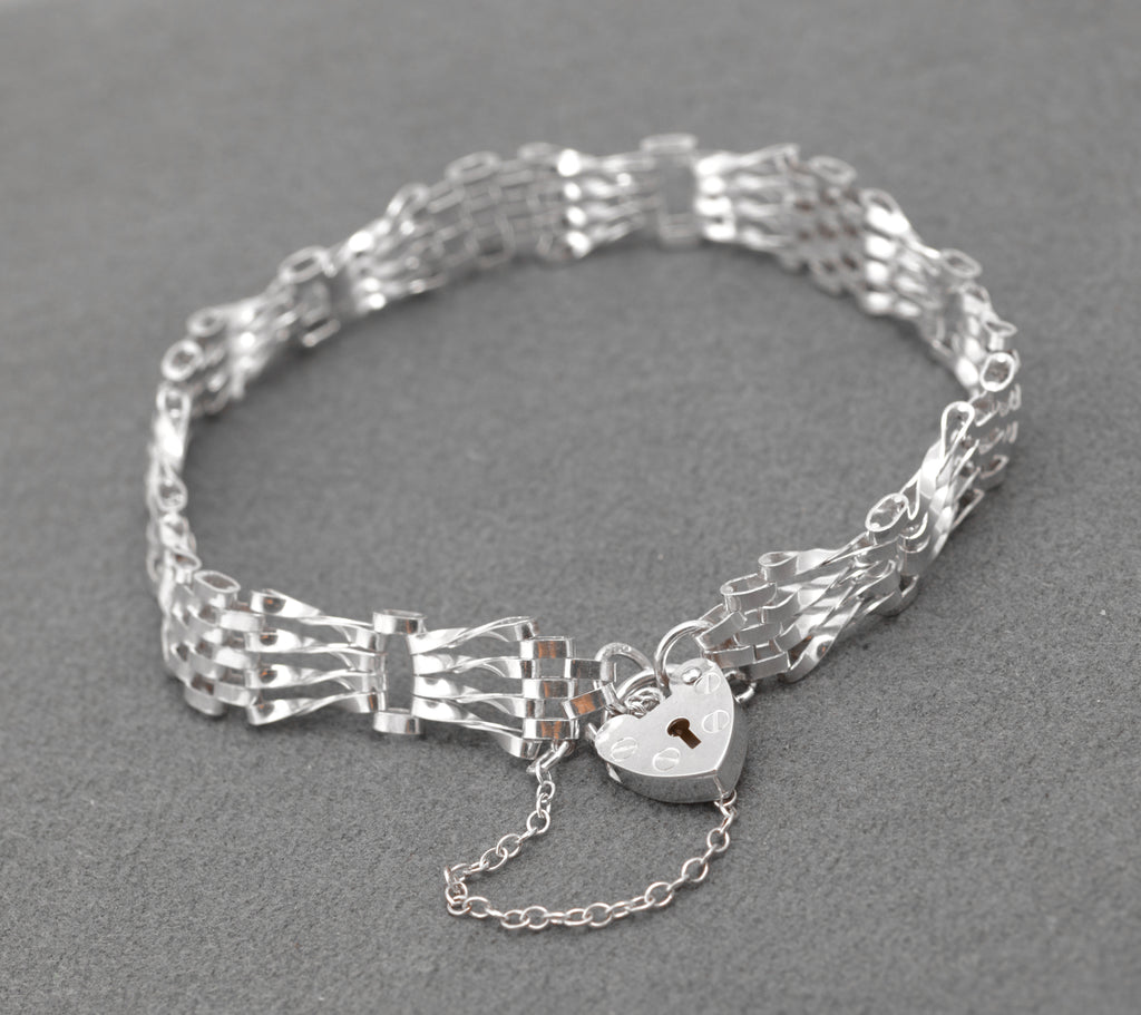 Vintage Sterling Silver Gate Bracelet - overhead view showing open gate link design and heart padlock on grey