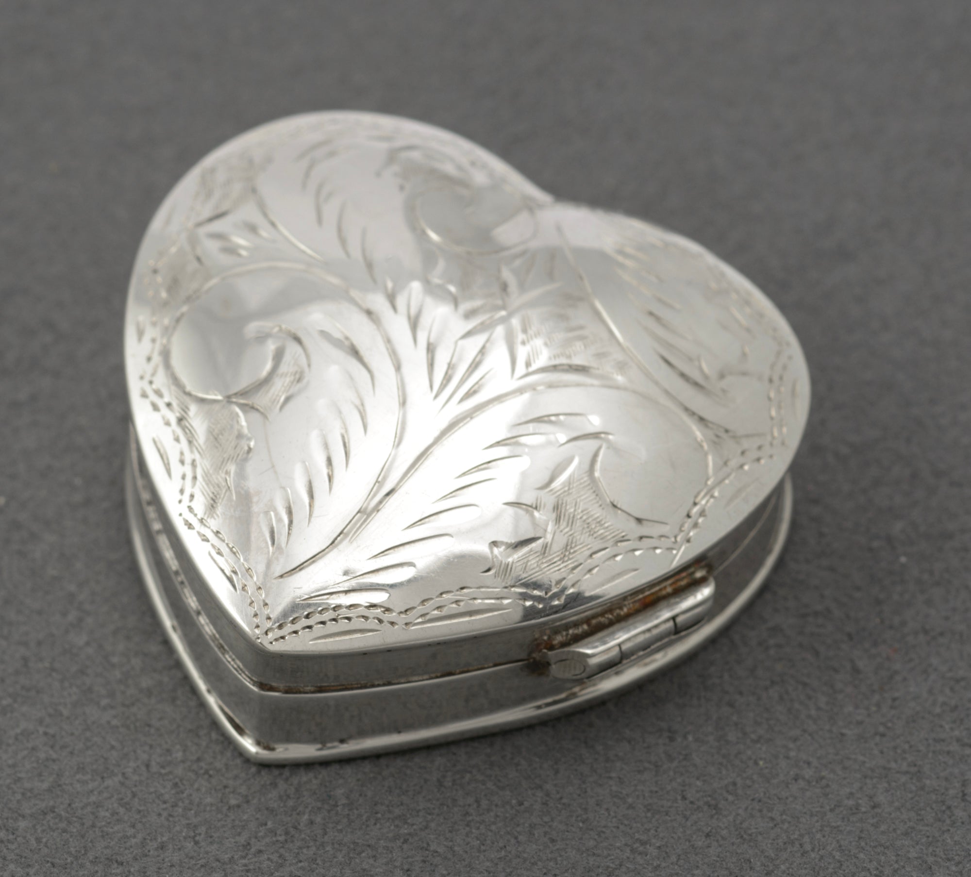 Vintage sterling silver heart shaped trinket box - close-up of hallmarks showing JMH maker mark, Sheffield import mark, 925 standard and date letter 1994
