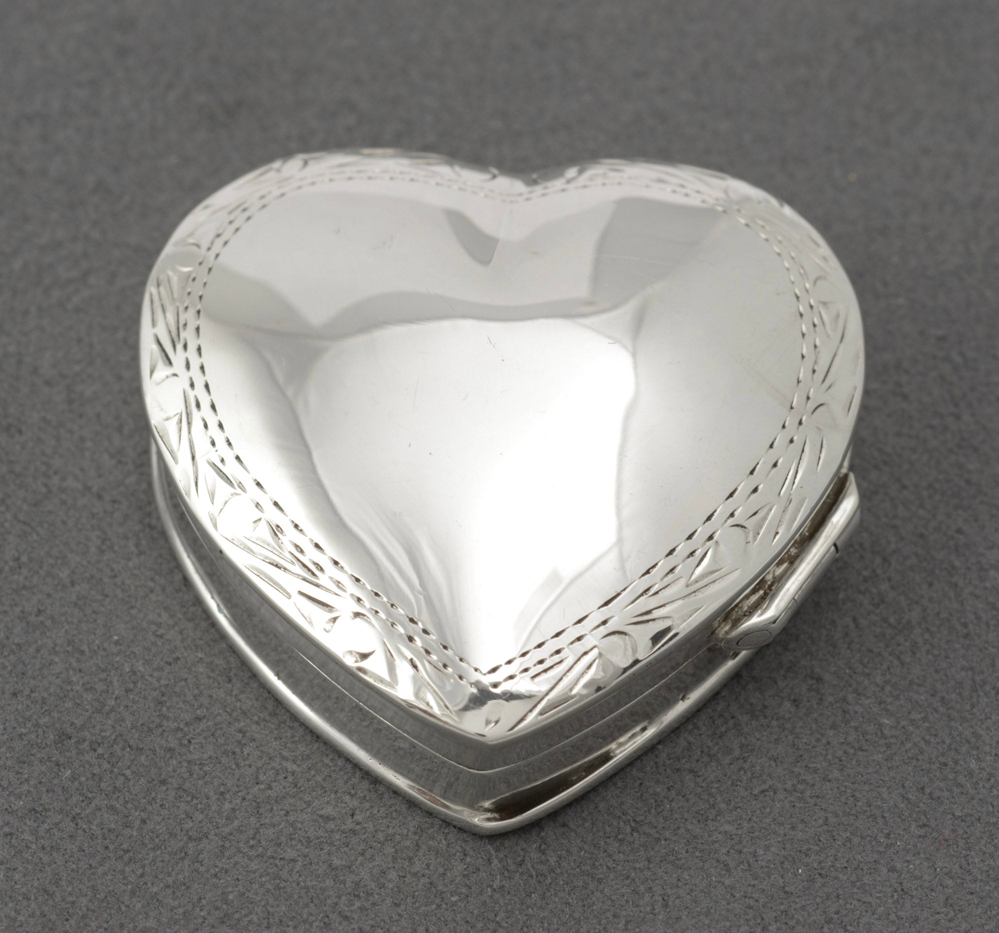 Vintage sterling silver heart shaped trinket box closed showing plain polished lid with engraved border, London 1993
