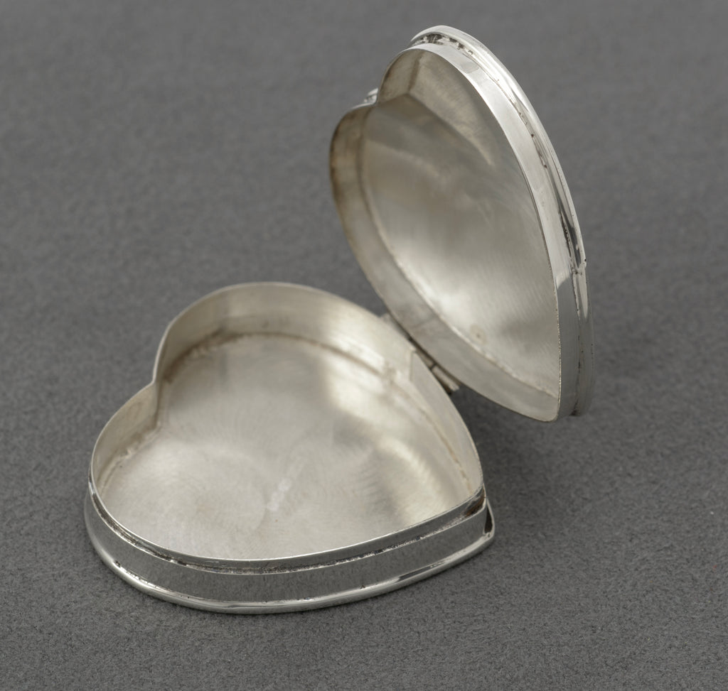 Vintage sterling silver heart shaped trinket box - three-quarter view showing engraved foliate border and friction fit closure