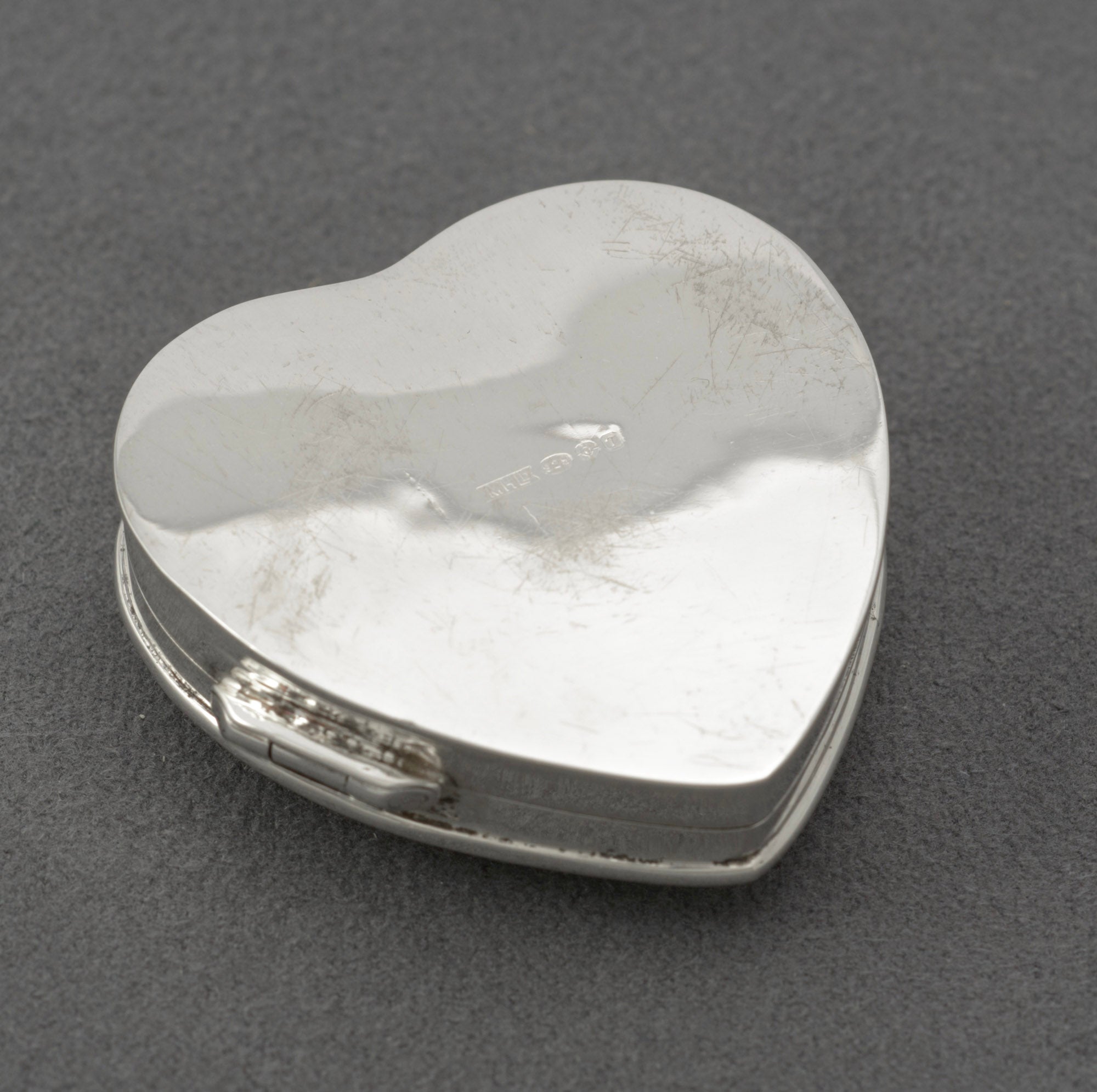 Vintage sterling silver heart shaped trinket box - reverse three-quarter view showing engraved border detail