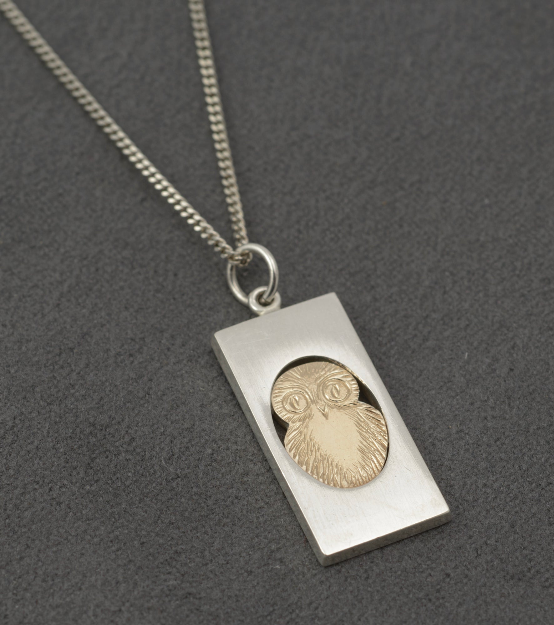 Vintage Finnish sterling silver owl pendant - angled view showing oval owl set within rectangular silver frame