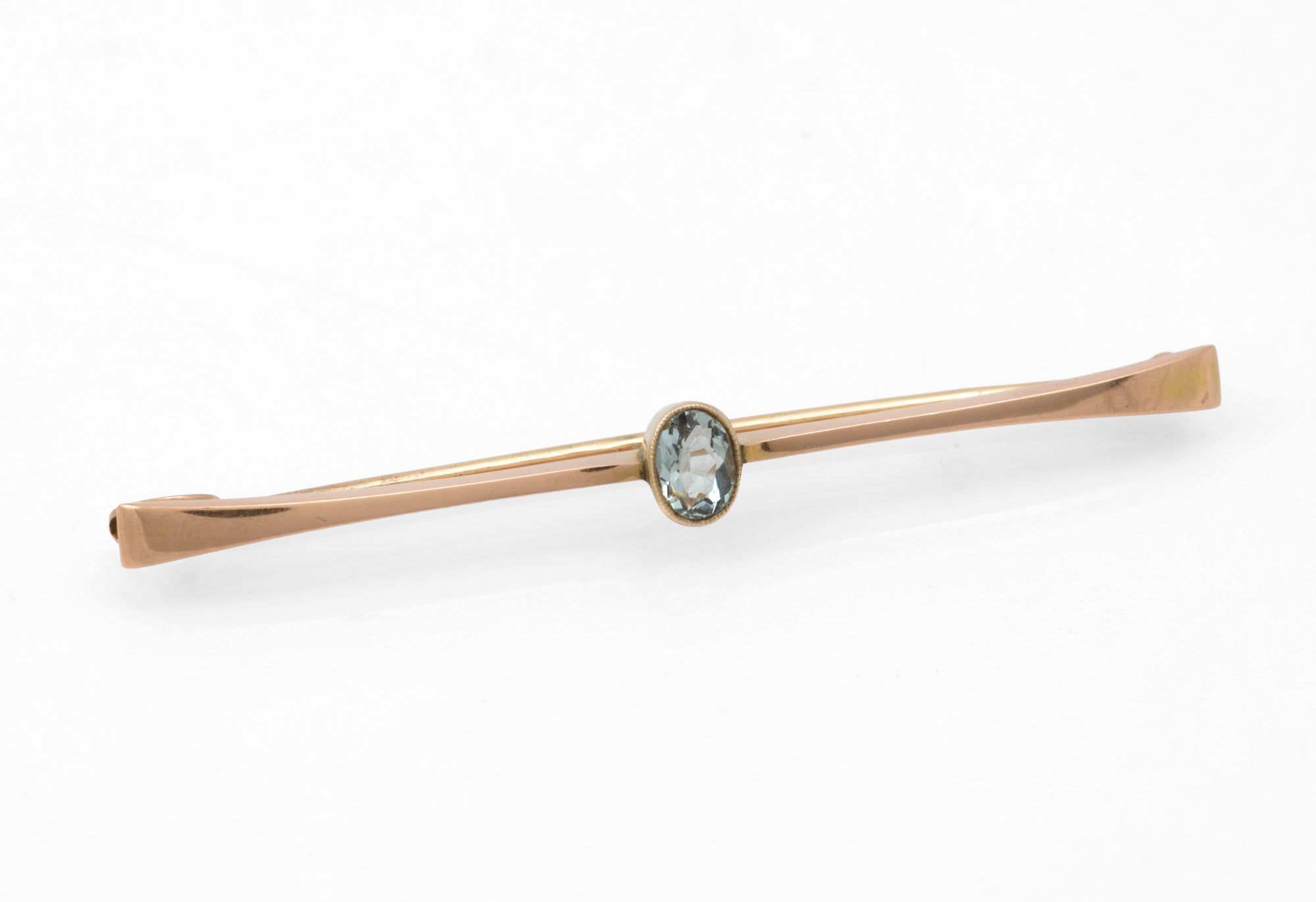 Art Deco 9ct rose gold and natural aquamarine bar brooch - front view showing oval aquamarine in raised collet at centre of tapered bar with flared terminals