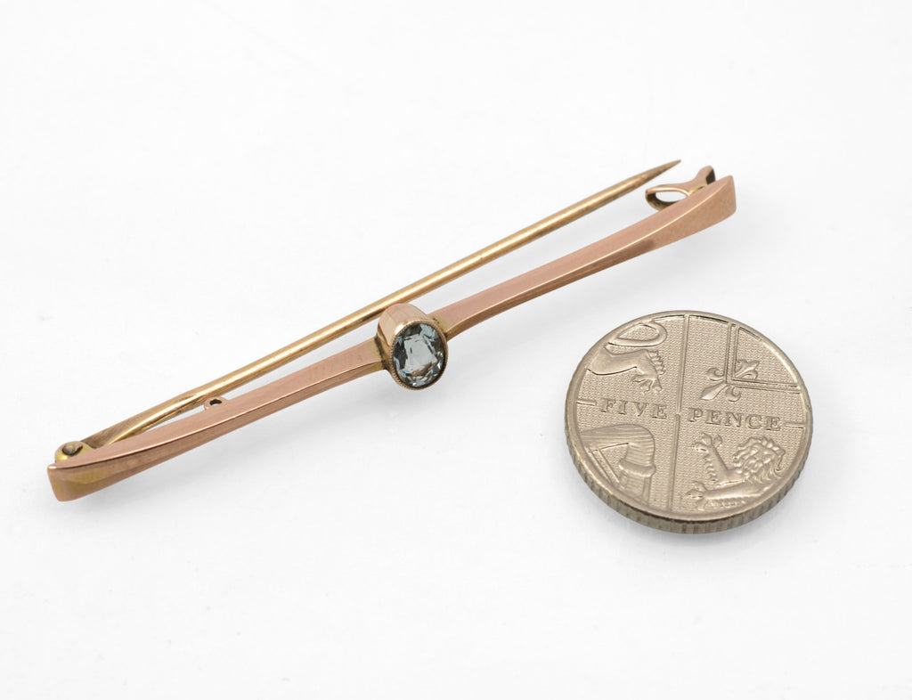 Art Deco 9ct rose gold aquamarine bar brooch - close-up of oval aquamarine in raised rub-over collet showing pale blue stone and rose gold surround