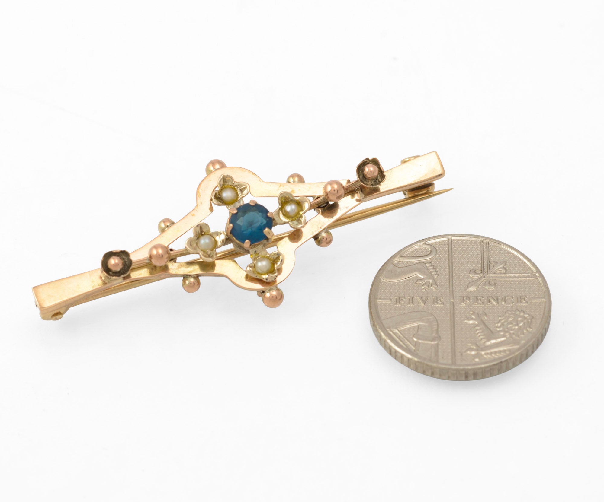 Antique 9ct gold bar brooch - scale reference showing brooch beside a five pence coin