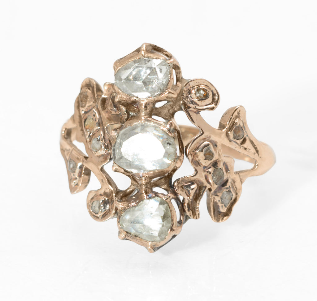 Georgian gold and diamond cluster ring - three-quarter front view showing portrait cut centre diamond with rose cut north and south stones and mixed mine and rose cut surround in open scrolling gold mount