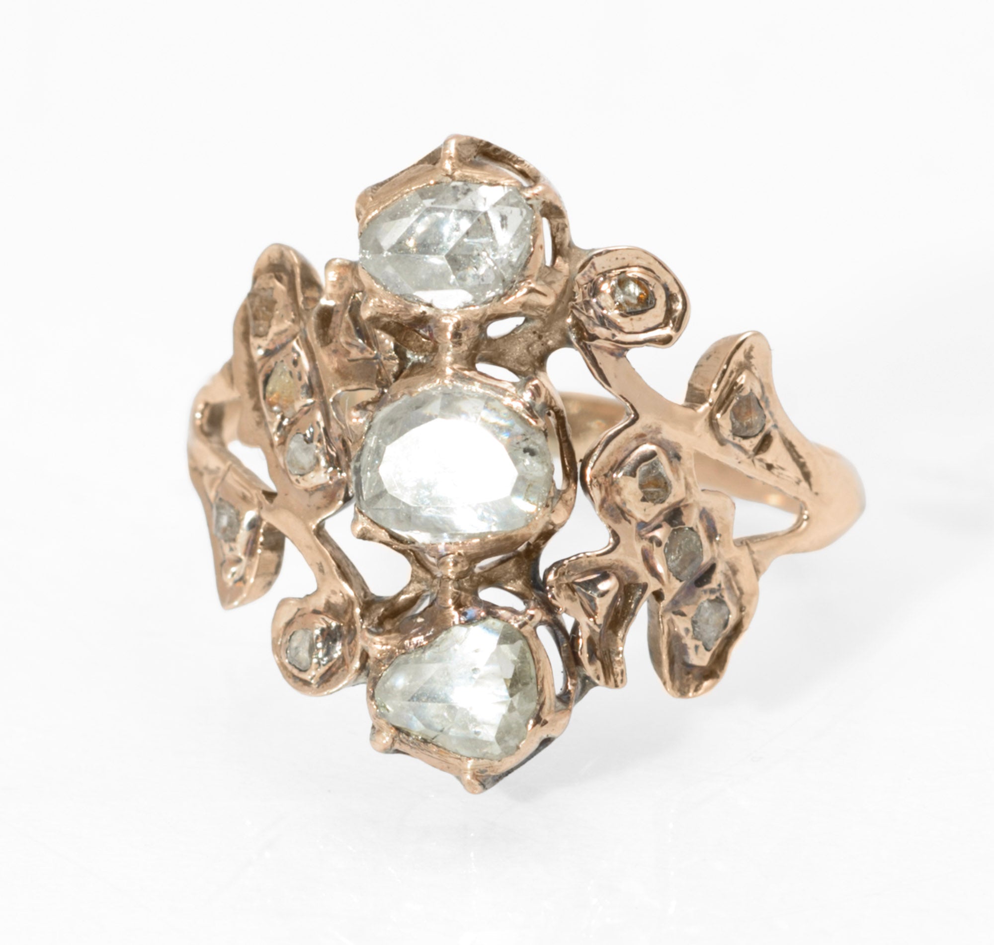 Georgian gold and diamond cluster ring - three-quarter front view showing portrait cut centre diamond with rose cut north and south stones and mixed mine and rose cut surround in open scrolling gold mount