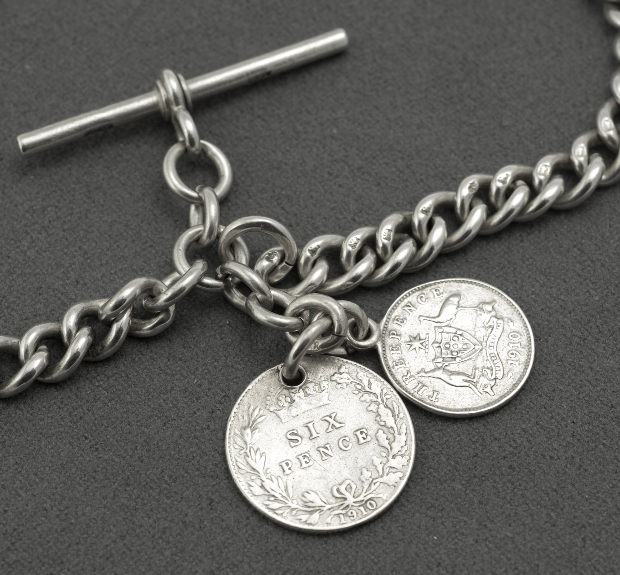 Antique sterling silver double Albert chain - full view laid flat showing twin dog clips, T-bar and two suspended 1910 silver coin drops