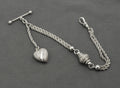 Antique Victorian sterling silver Albertina watch chain - close up of ornate drum-shaped central feature with floral and scrolling detail and polished ball spacers on multi-strand rope chains