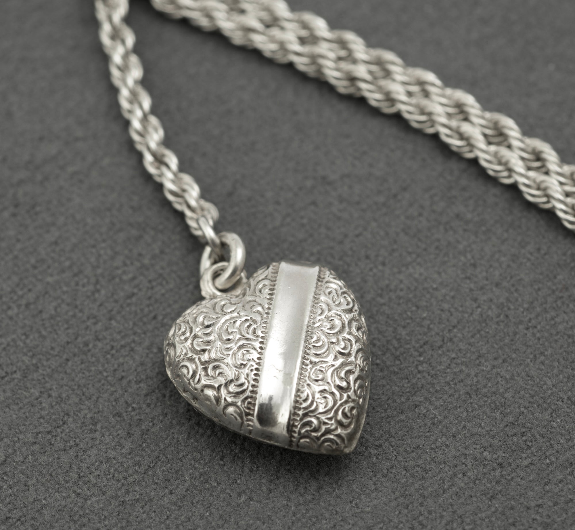 Antique Victorian sterling silver Albertina chain - full view on grey background showing T-bar, ornate central feature, heart fob and dog clip arranged as worn