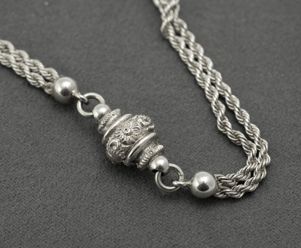 Antique Victorian sterling silver Albertina chain - close up of heart fob and dog clip showing scrolling decoration to either side of plain central band and swivel fitting