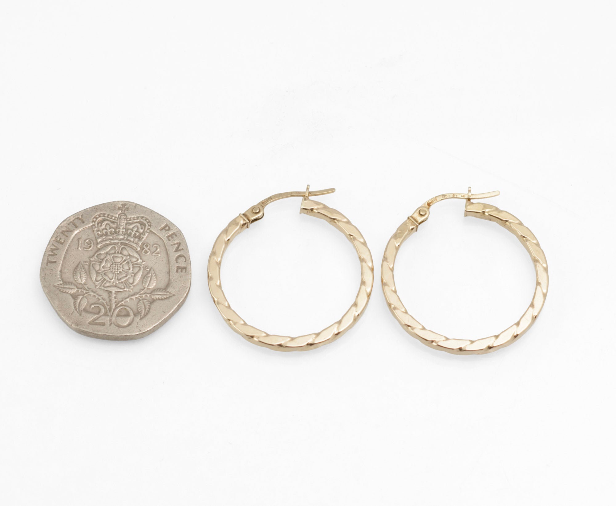 Vintage 9ct gold Unoaerre hoop earrings - detail of angular rope twist pattern showing light reflection across polished surface
