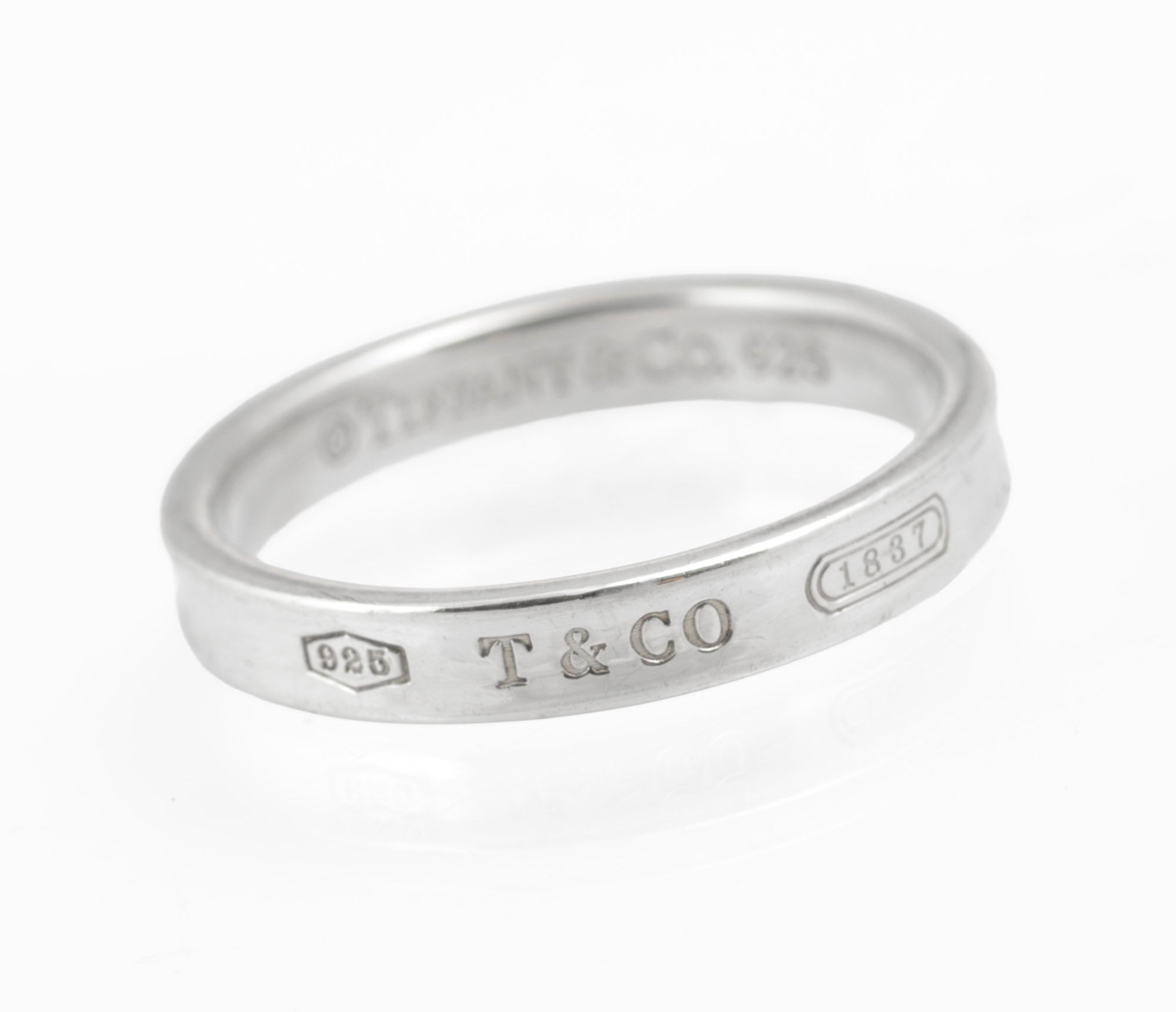 Vintage Tiffany & Co. 1837 sterling silver band ring - angled view showing T&CO and 1837 cartouche engravings on outer band