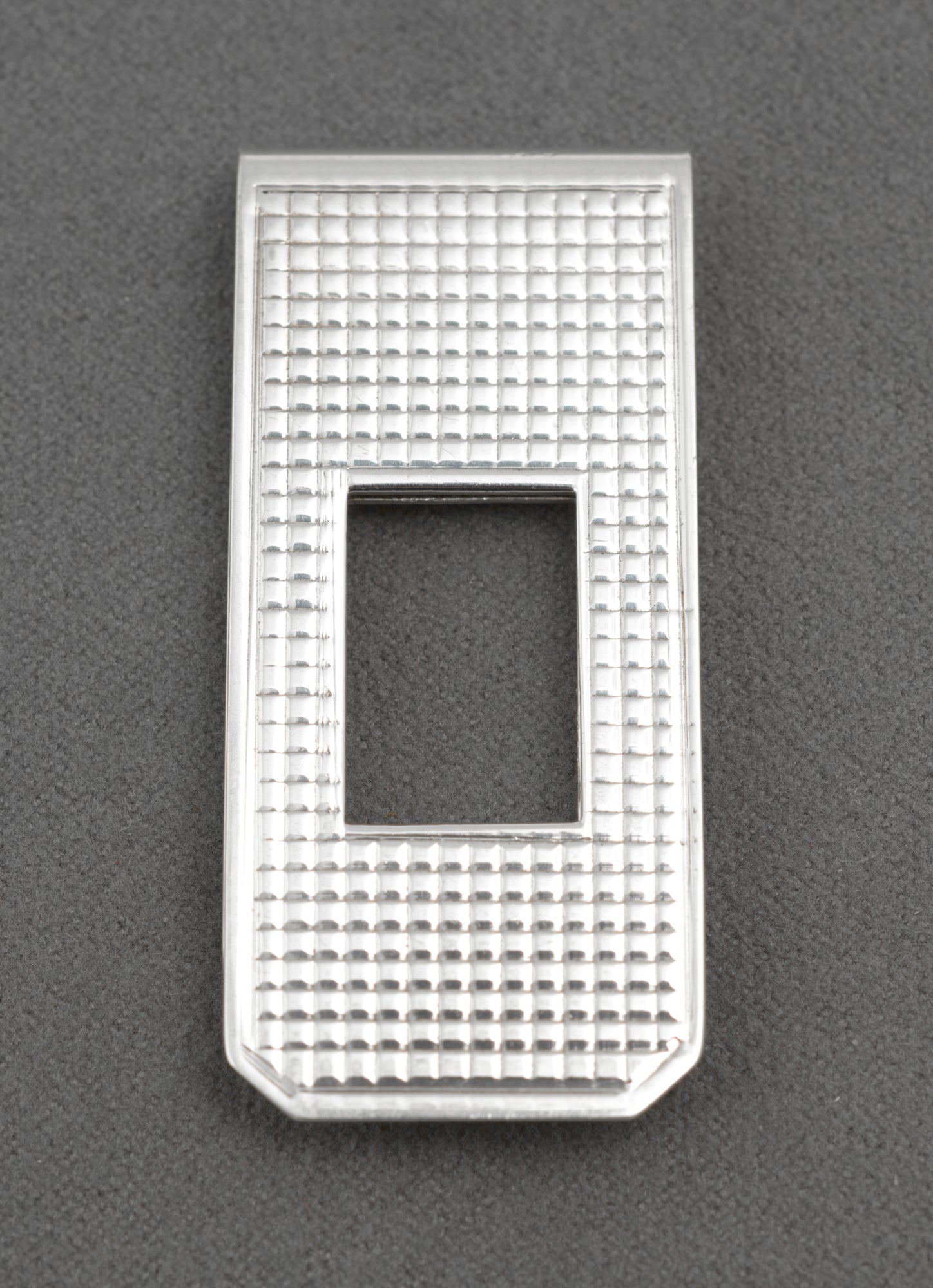 Vintage sterling silver money clip - angled three-quarter view on white background showing engine-turned front face and polished border