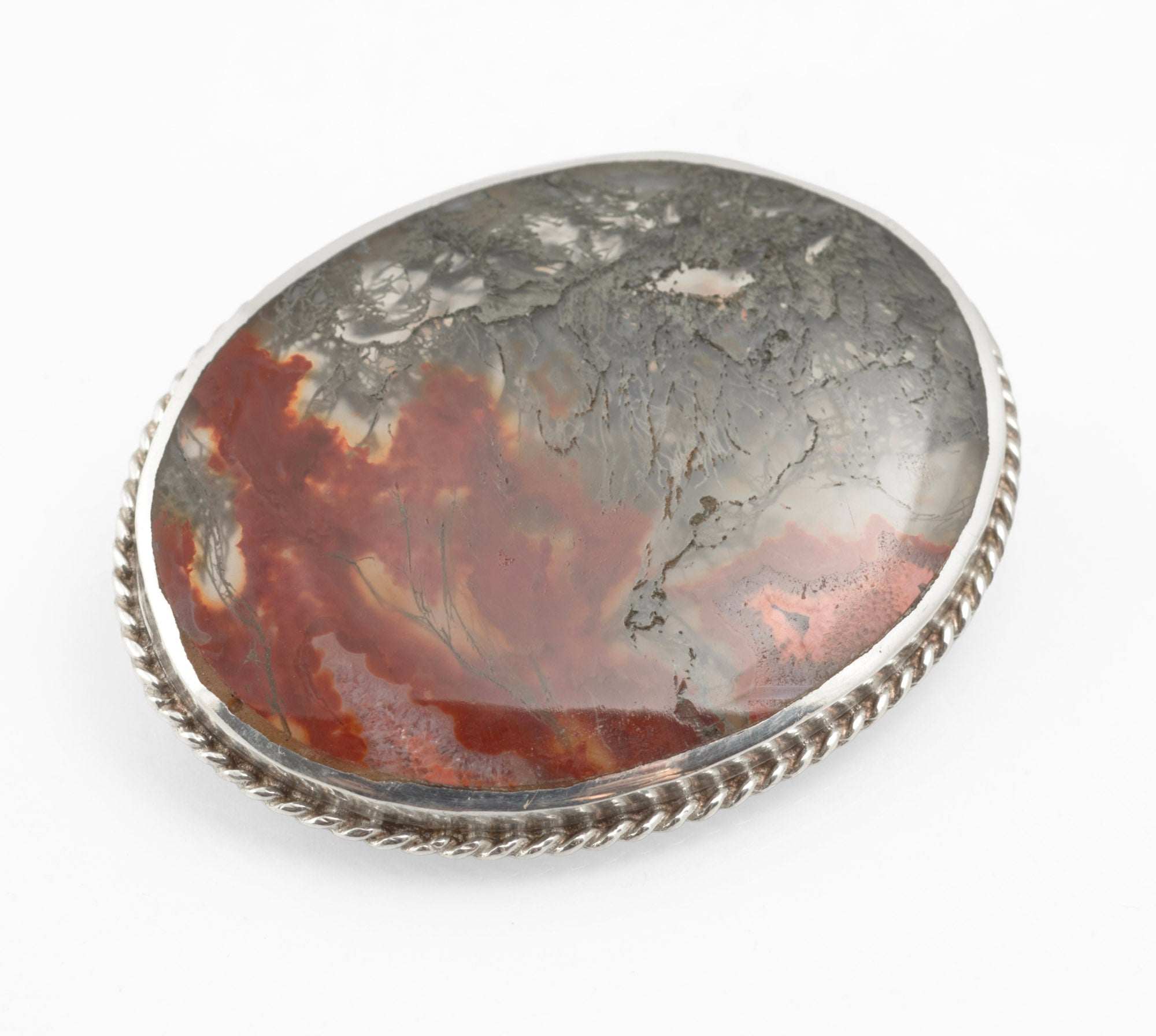 A large sterling silver brooch by C W Sellors Ltd, set with a natural cabochon in which translucent moss agate gives way to rich carnelian. Fully hallmarked at Sheffield for 1997.
