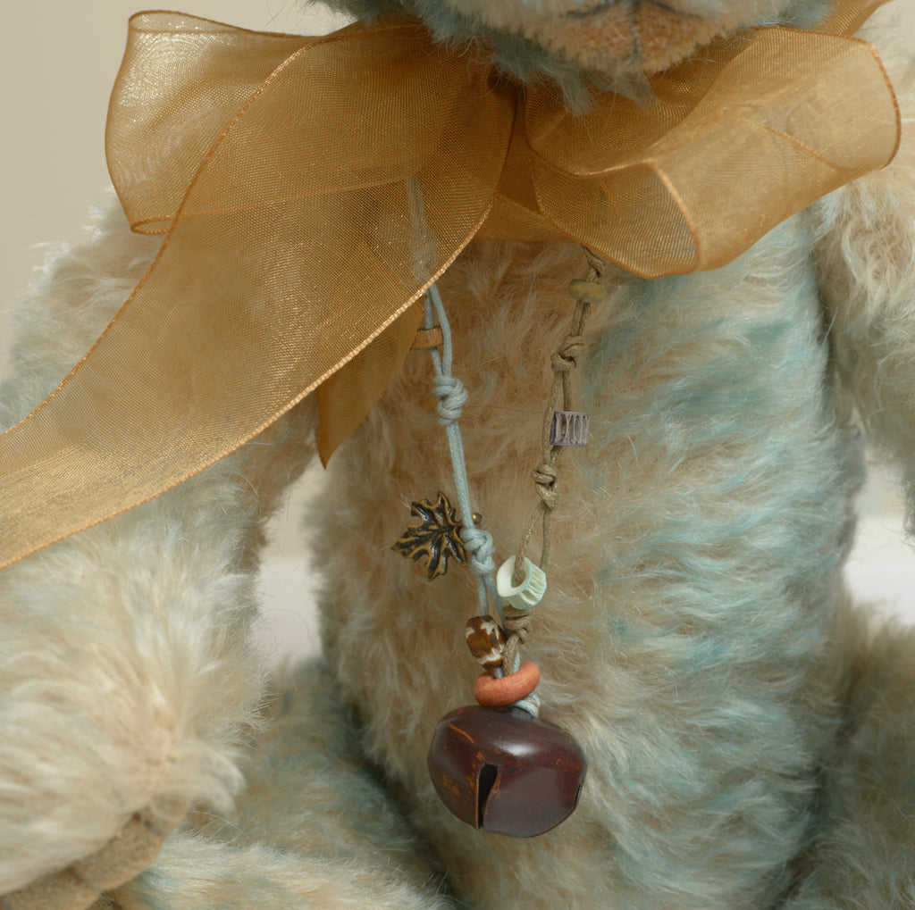Charlie Bears Wordsworth - Isabelle Collection - necklace detail showing knotted leather cord with bronze leaf charm, mixed beads and dark bronze bell