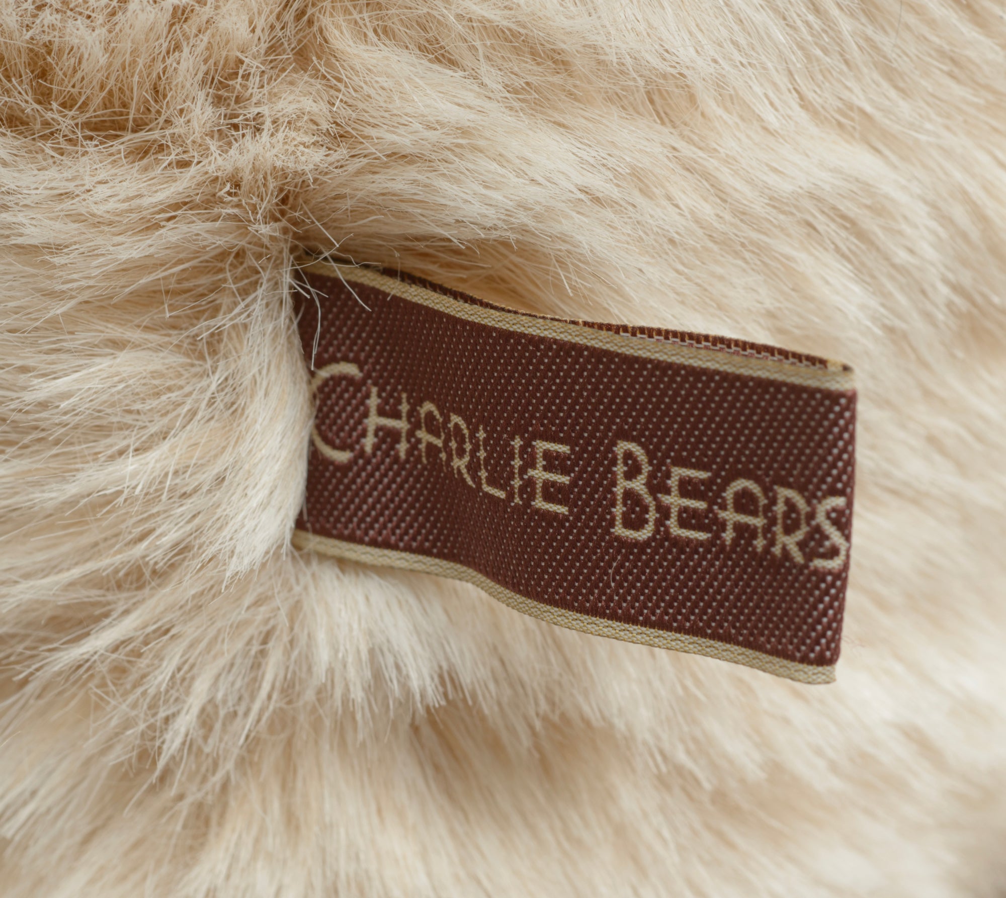 Charlie Bears Kenny - Isabelle Collection - detail of knitted scarf charm showing small knitted bear in burgundy and brown