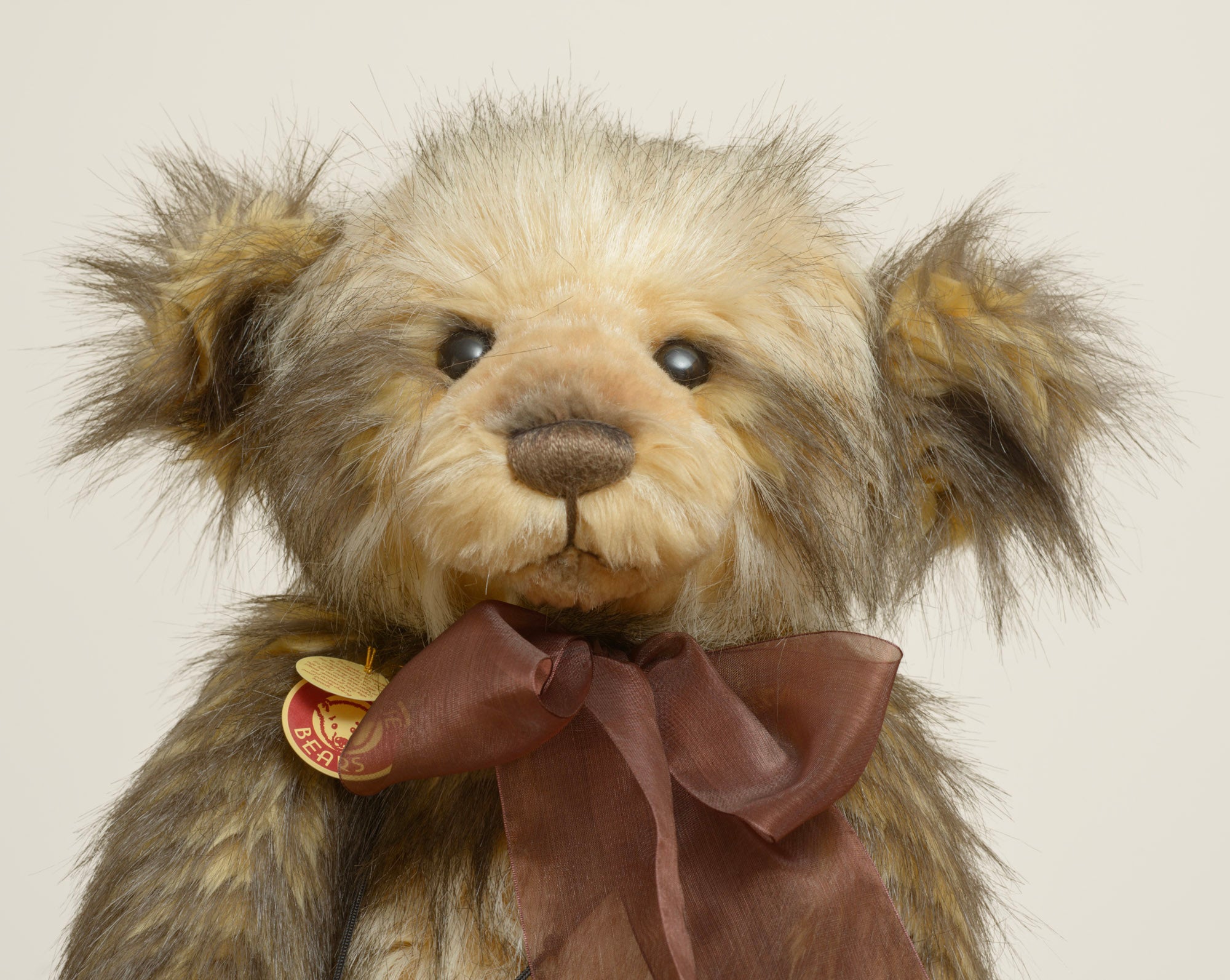 Charlie Bears Dorian - Isabelle Collection - necklace detail showing dark braided cord with wooden beads, bone toggle and large dark bronze bell