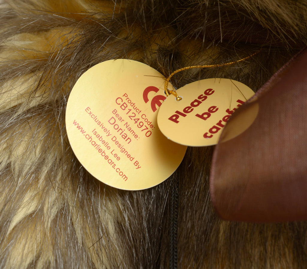 Charlie Bears Dorian - Isabelle Collection - paw pad detail showing large plain dark brown suede-effect pad alongside bell necklace