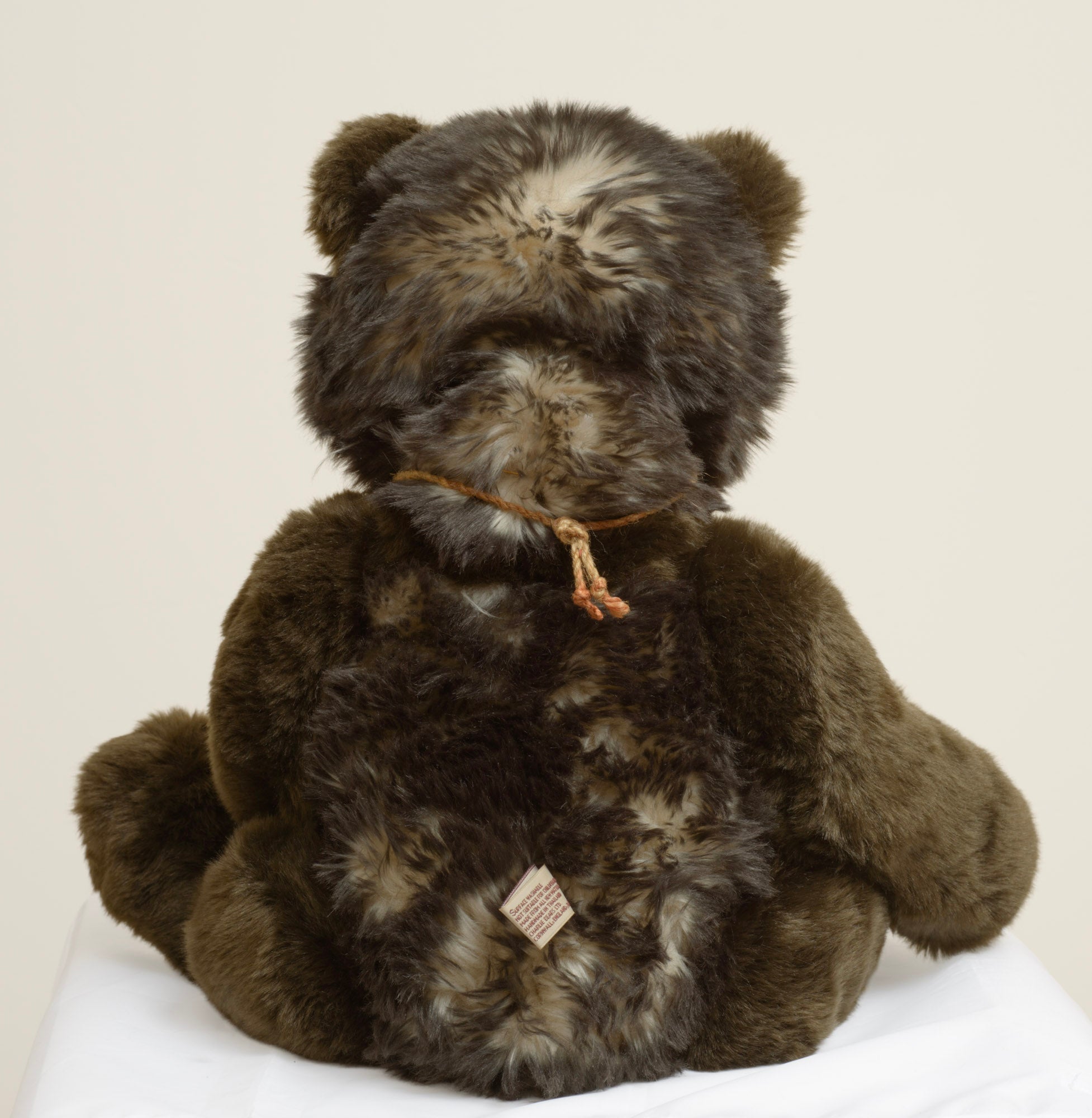 Charlie Bears Breeny - Isabelle Collection - full front view showing dark chocolate and cream tipped plush with jute rope necklace and copper bell