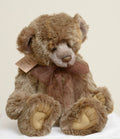 Charlie Bears William III - close up face showing sandy taupe tipped plush, cream muzzle, dark glass eyes and warm brown nose with swing tag visible
