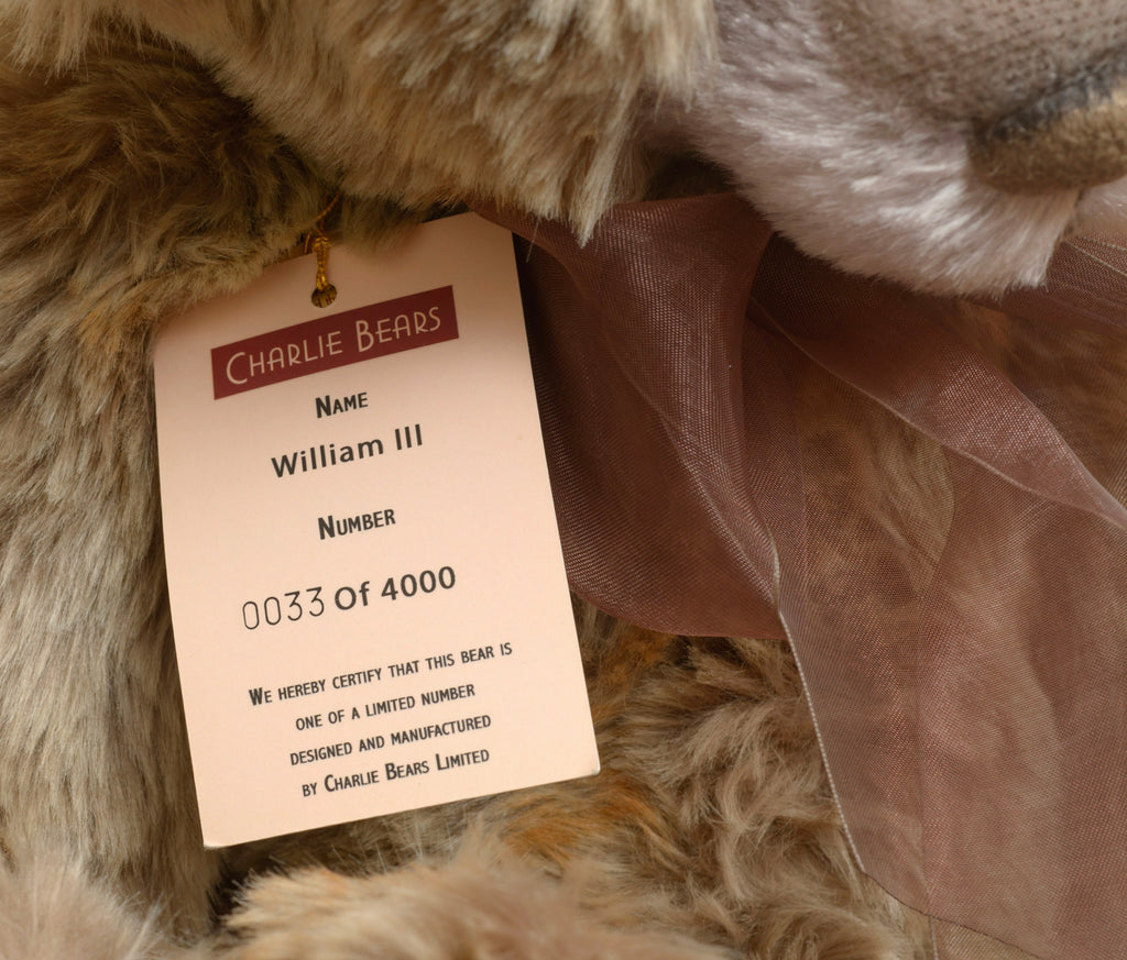 Charlie Bears William III - gold hang tag showing product code CB1040, bear name William III, exclusively designed by Isabelle Lee, with Certificate of Authenticity card