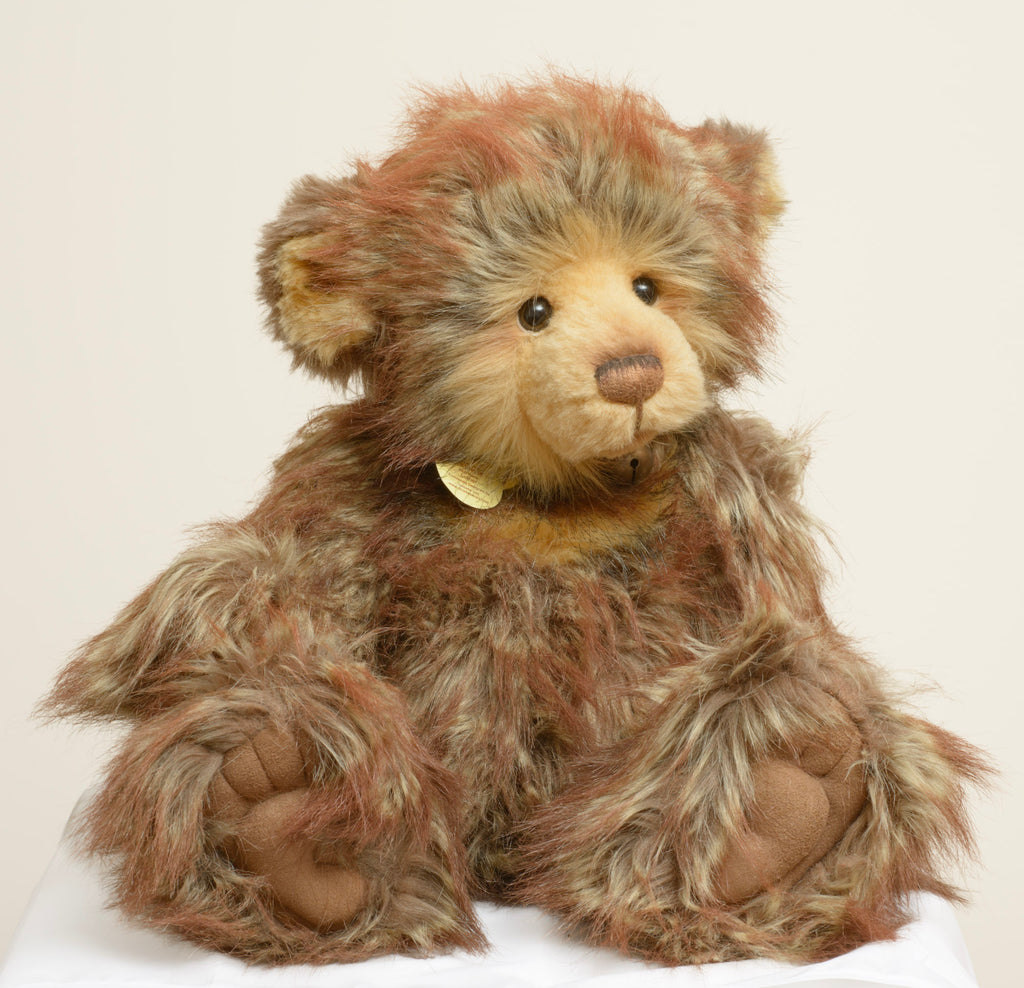A large Charlie Bears Isabelle Collection bear named Luther, in a rich multi-tonal brown long pile plush, wearing a brown leather effect collar hung with three jingle bells.