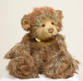 A large Charlie Bears Isabelle Collection bear named Luther, in a rich multi-tonal brown long pile plush, wearing a brown leather effect collar hung with three jingle bells.