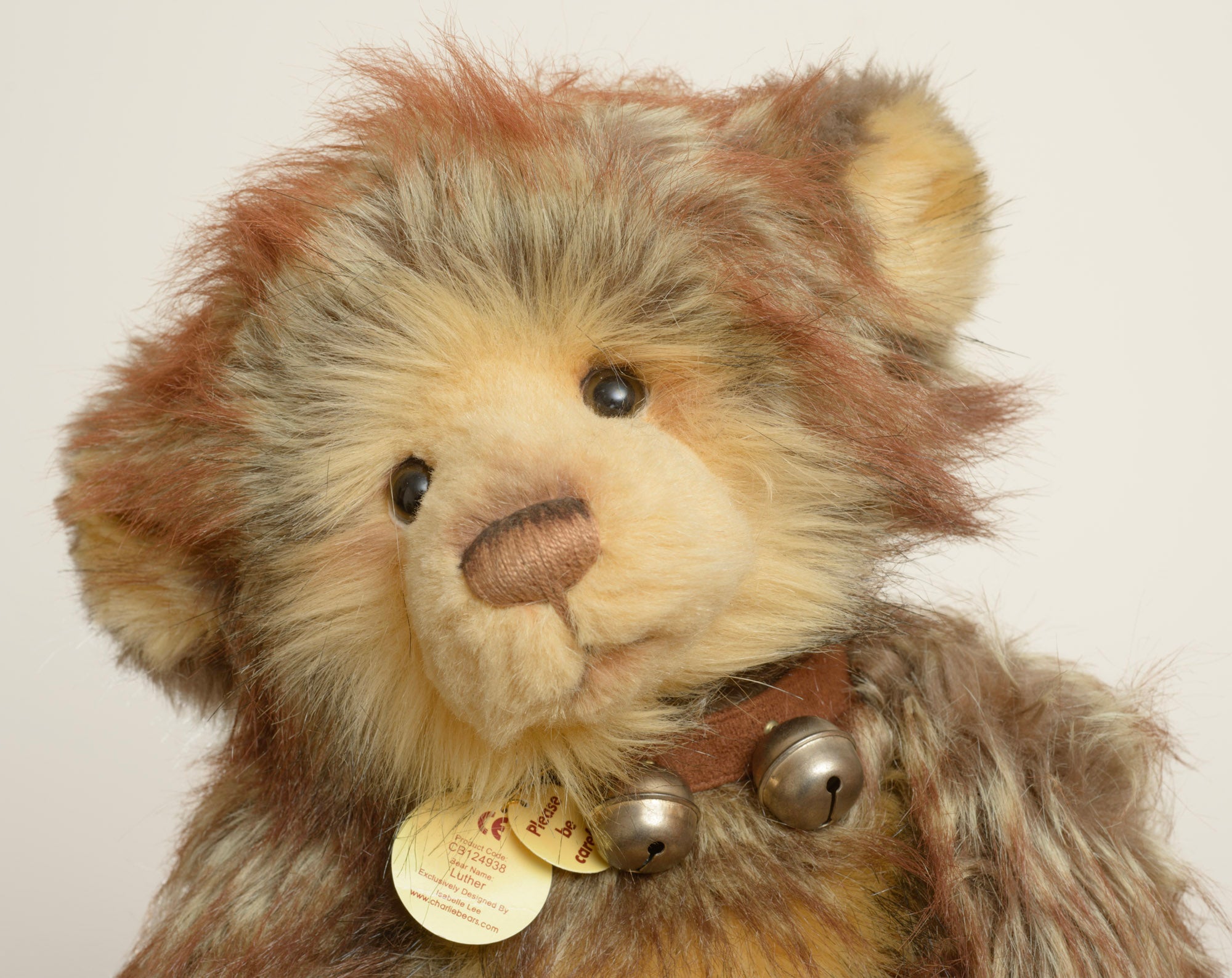 A large Charlie Bears Isabelle Collection bear named Luther, in a rich multi-tonal brown long pile plush, wearing a brown leather effect collar hung with three jingle bells.
