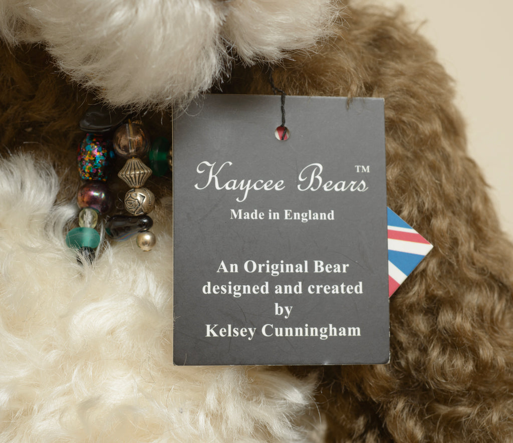 Kaycee Bears Simkin - Kelsey Cunningham - rear view showing dark chocolate curly plush coat, cream ivory tummy panel and AN ORIGINAL Kaycee woven label in gold on dark brown