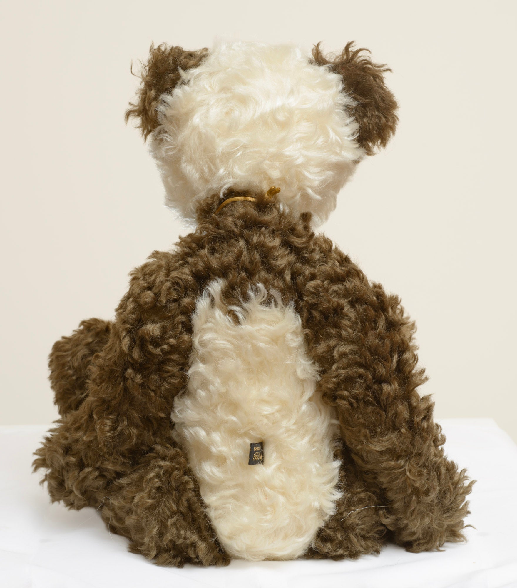 Kaycee Bears Simkin - Kelsey Cunningham - three-quarter front view showing cream curly plush face with dark glass eyes, sculpted dark brown nose and mixed bead necklace on old gold strand