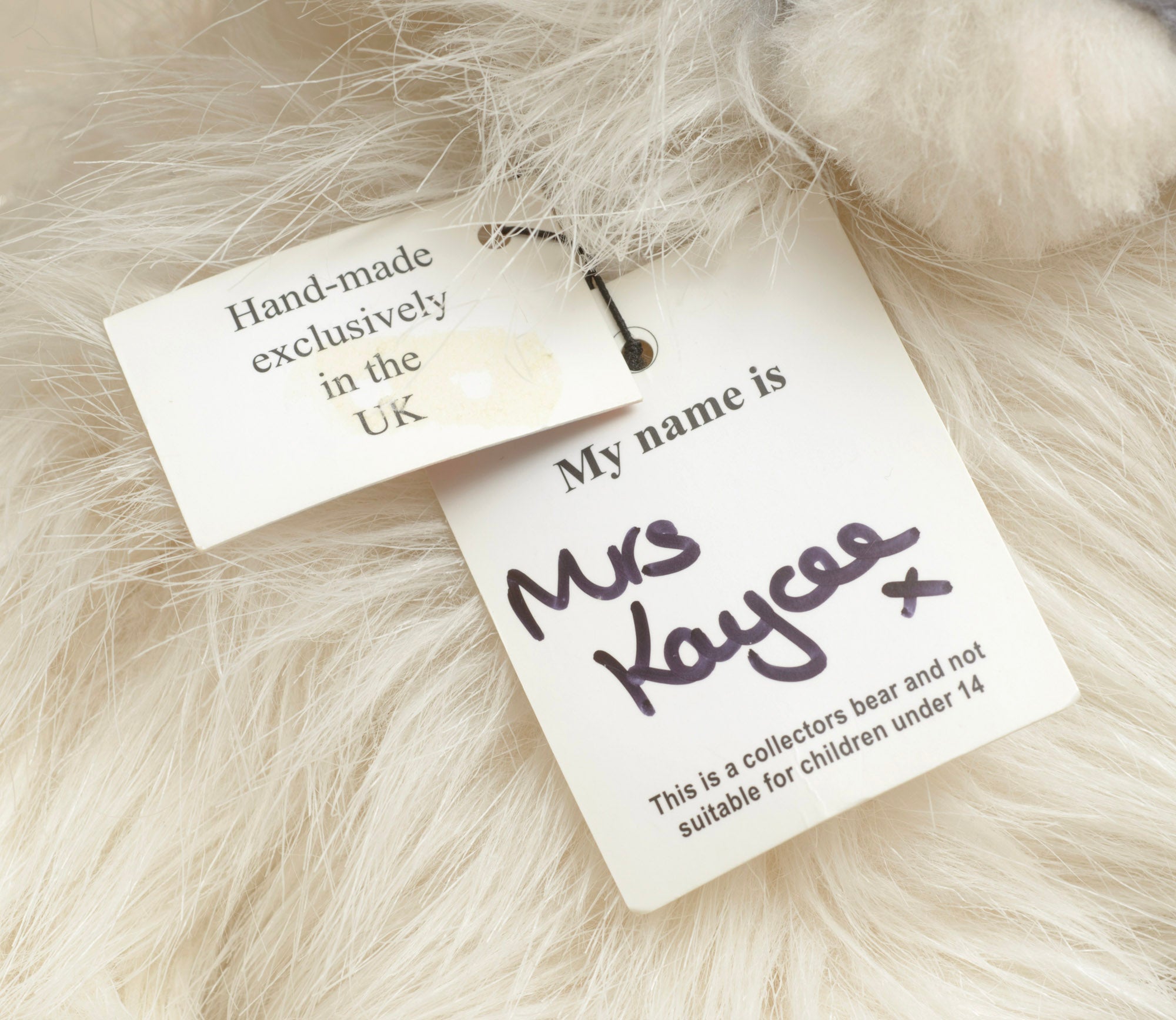 Kaycee Bears Mrs Kaycee - Kelsey Cunningham - rear view showing long cream ivory plush coat with pink satin bow and AN ORIGINAL Kaycee woven label set on the diagonal