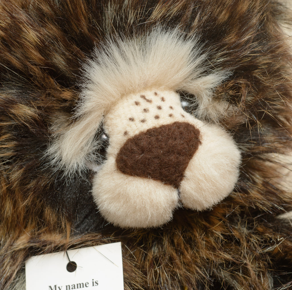 Mr Kaycee is a long dark tipped plush bear from Kaycee Bears, designed and created by Kelsey Cunningham in England, with a full cream muzzle panel and a scattering of dark freckle stitches across the upper muzzle, wearing an elasticated gold coloured cord necklace with a single aged gold bell.