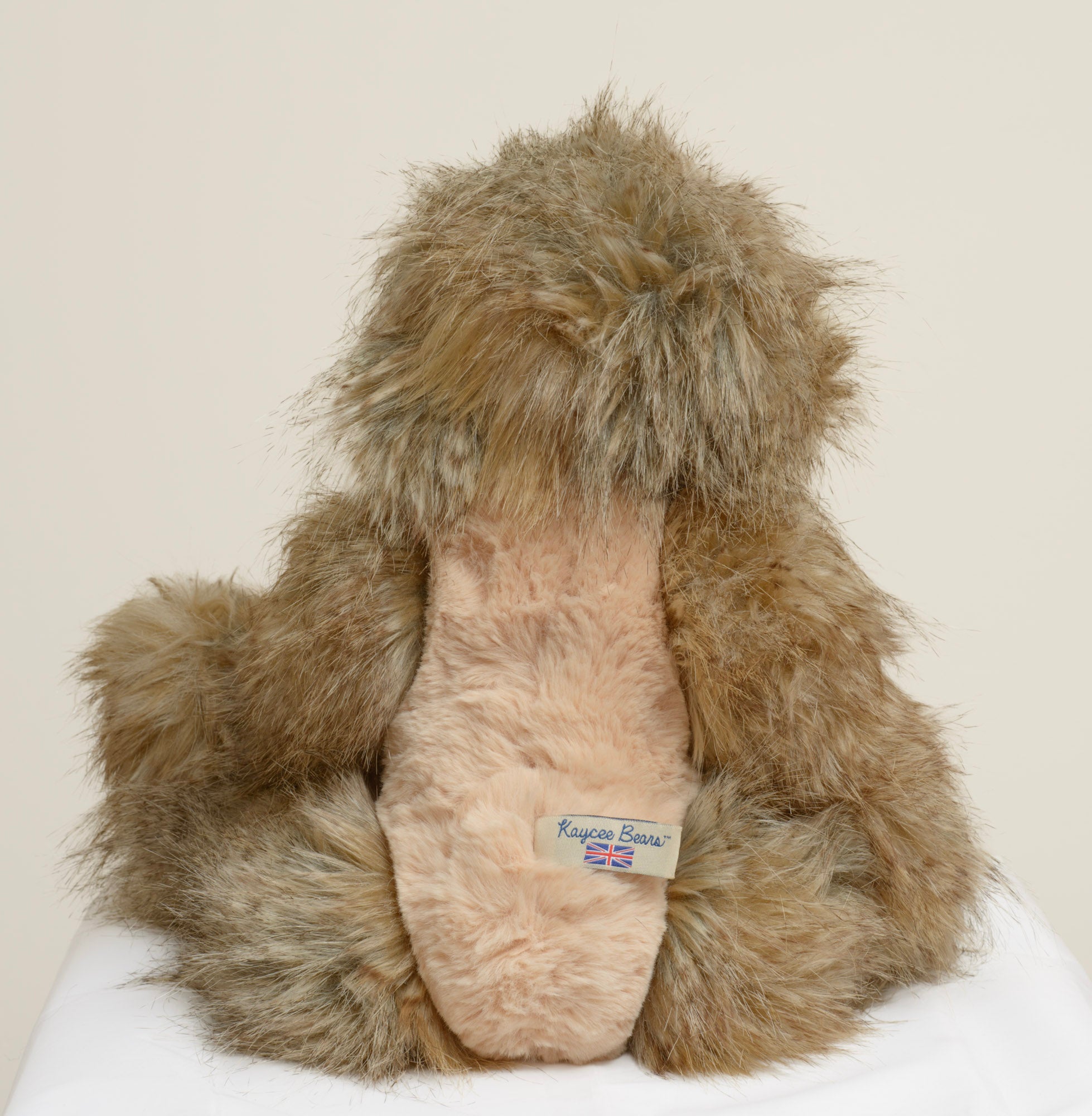 Kaycee Bears Hugglesome - Kelsey Cunningham - three-quarter view showing contrast between long wild sandy taupe outer coat and shorter blush pink curly plush tummy panel and inner ears