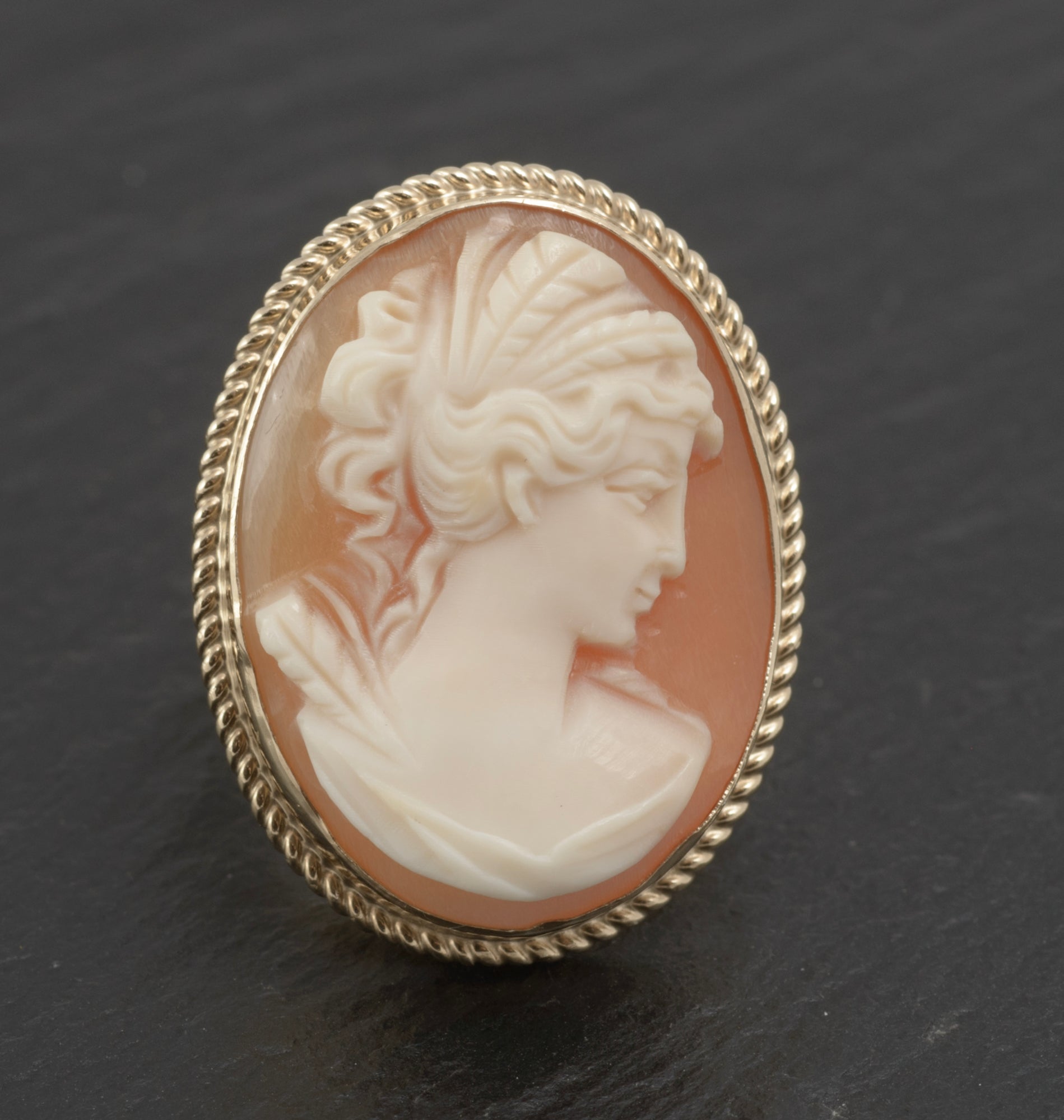Vintage 9ct gold cameo ring - large carved shell portrait cameo - full front view on white background showing classical female profile in high relief with pale cream portrait against warm peach shell ground in rope twist bezel