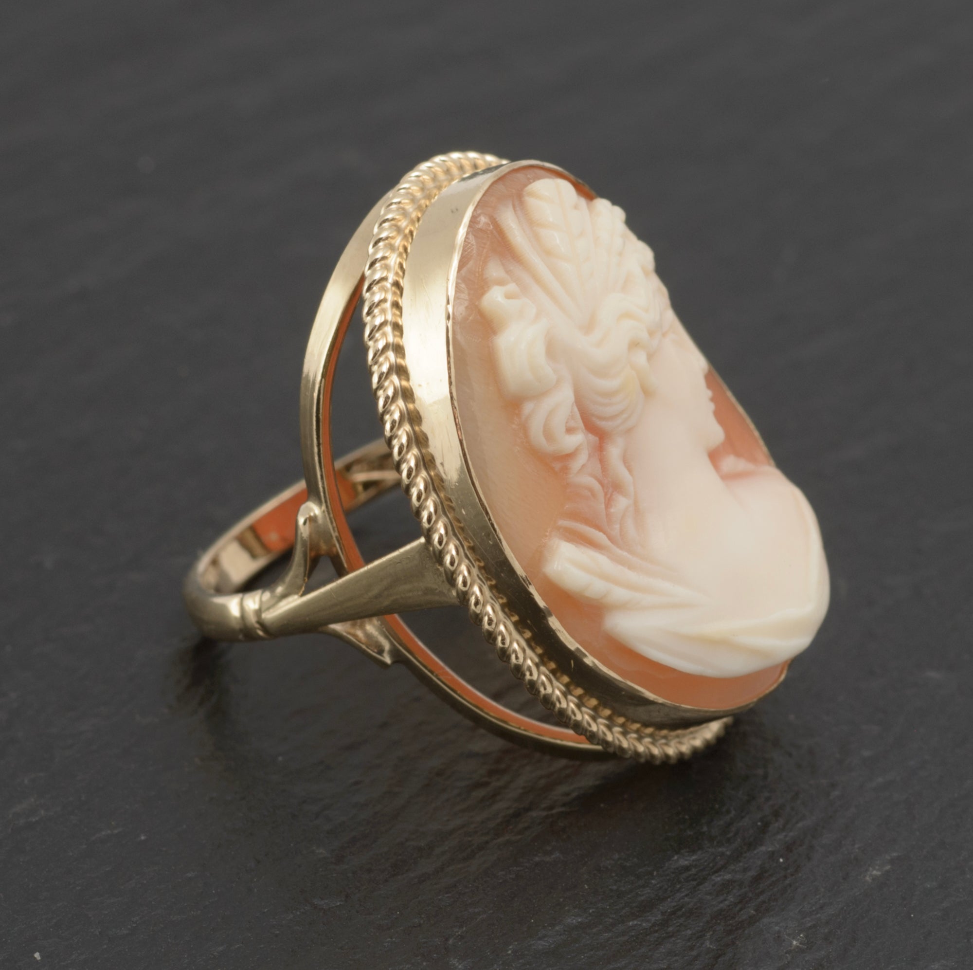 Vintage 9ct gold cameo ring - large carved shell portrait cameo - angled side view on white background showing scale of 28mm oval cameo head above open gallery mount and broad gold band