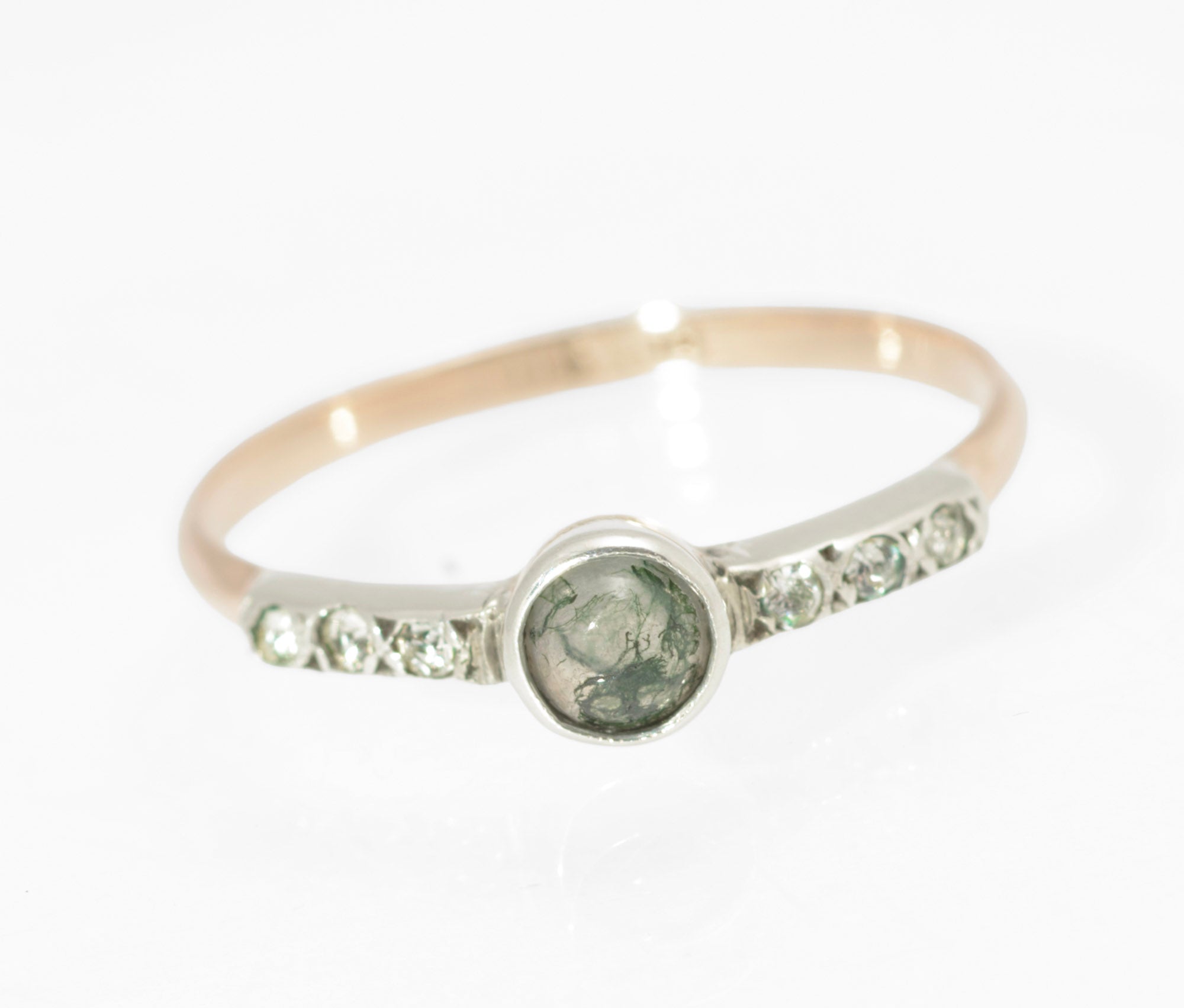 Art Deco moss agate ring - 9ct rose gold and silver - three-quarter side view showing warm rose gold band transitioning to cool silver head with paste set shoulders on white background