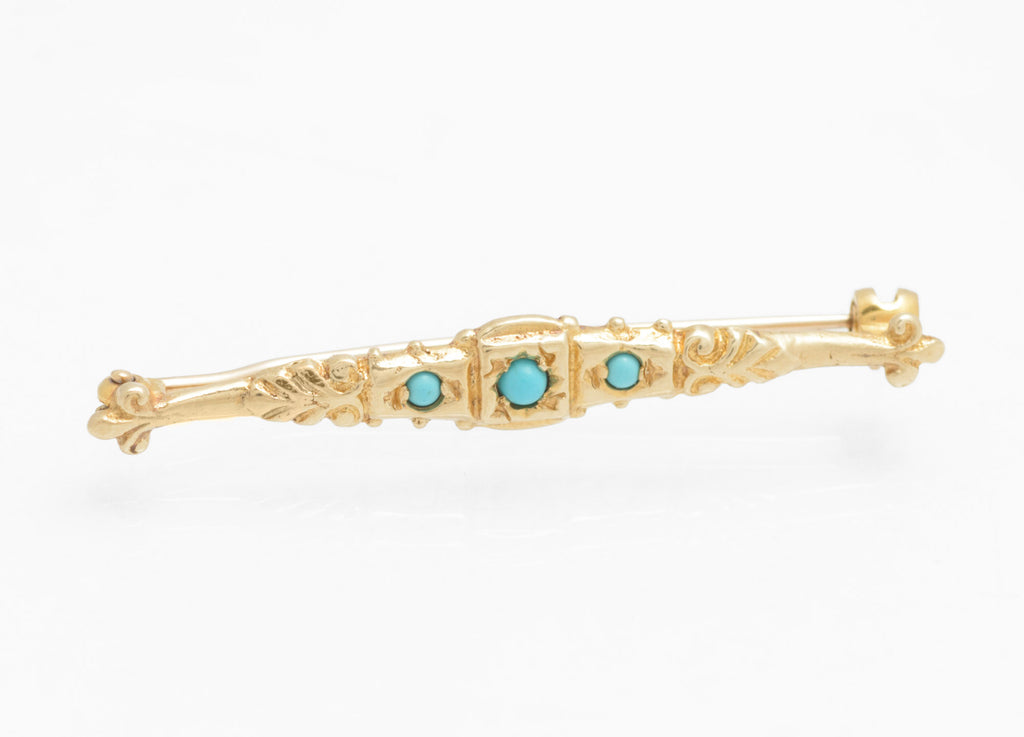 Vintage 9ct gold bar brooch - natural turquoise - Edwardian revival - front view showing three turquoise cabochons with raised central square collet setting flanked by scrolling acanthus leaf decoration and bead accents on white background