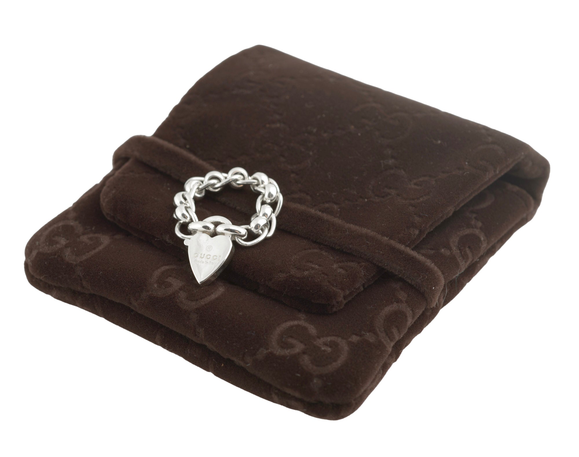 Gucci sterling silver chain link ring with heart charm - close up of ring on GG monogram soft brown pouch showing articulated oval rolo chain links and heart charm with Gucci engraving on dark background