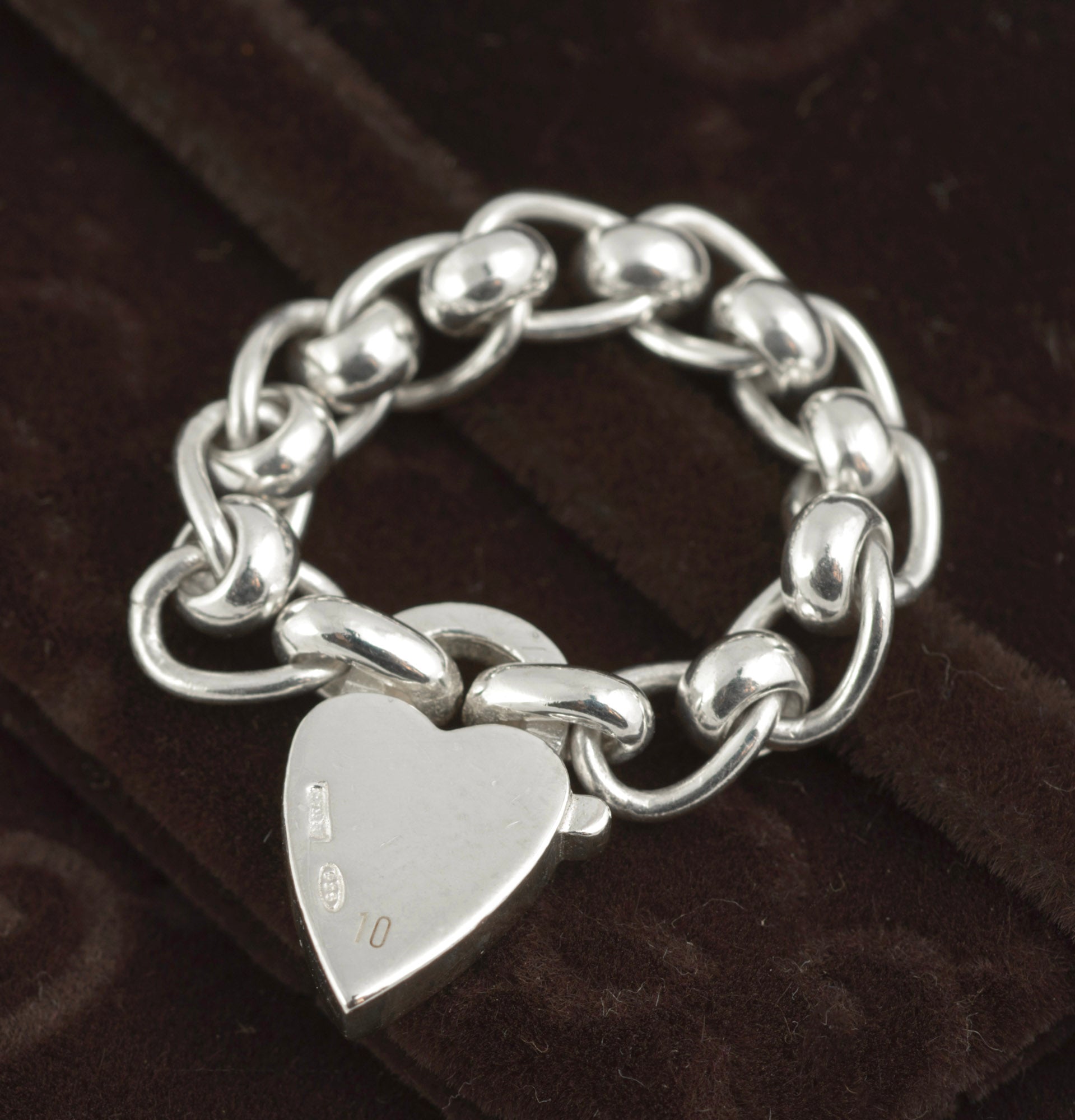 Gucci sterling silver chain link ring with heart charm - reverse view of heart charm showing Italian silver hallmarks and 925 sterling silver mark to lower left on dark background