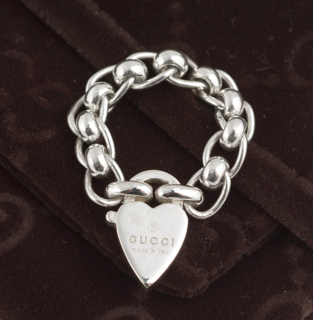 Gucci sterling silver chain link ring with heart charm - front view of heart charm showing Gucci name and made in italy engraving with articulated oval rolo chain links visible on dark background
