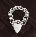 Gucci sterling silver chain link ring with heart charm - front view of heart charm showing Gucci name and made in italy engraving with articulated oval rolo chain links visible on dark background