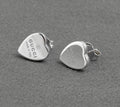 Gucci sterling silver heart stud earrings - made in Italy - pair shown from front and side on grey background showing polished heart form with Gucci name and made in italy engraving and butterfly back fittings