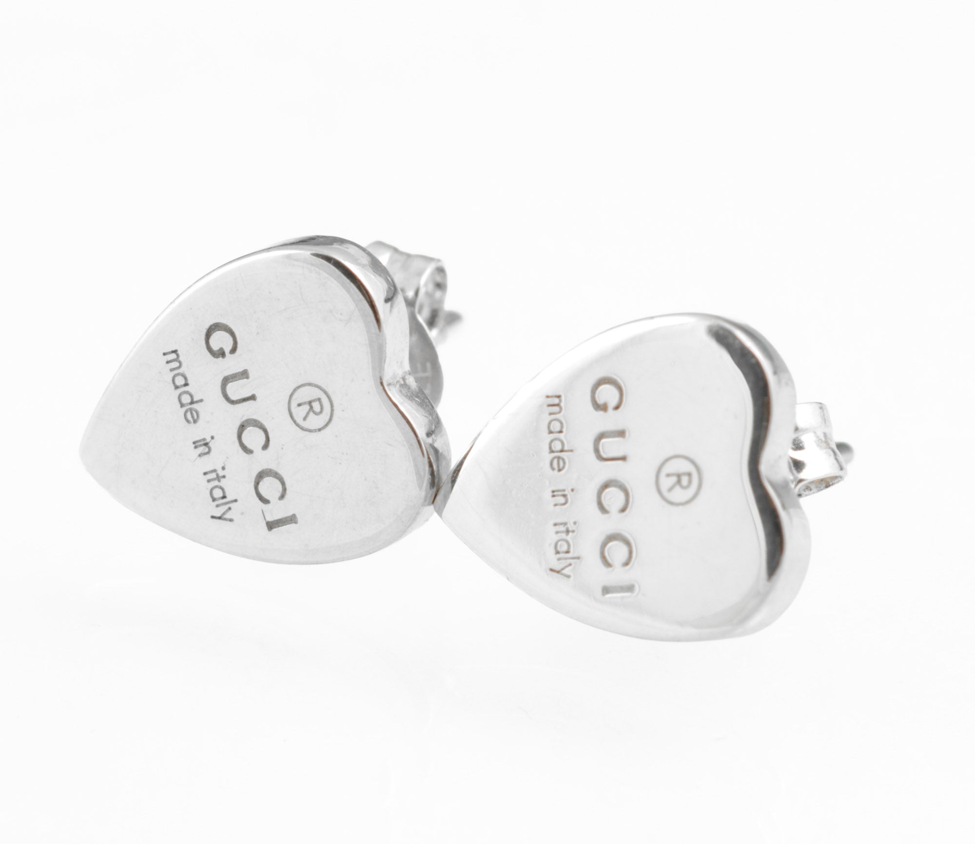 Gucci sterling silver heart stud earrings - made in Italy - pair shown front face on white background showing both hearts with Gucci name and made in italy engraving and registered trademark symbol clearly visible
